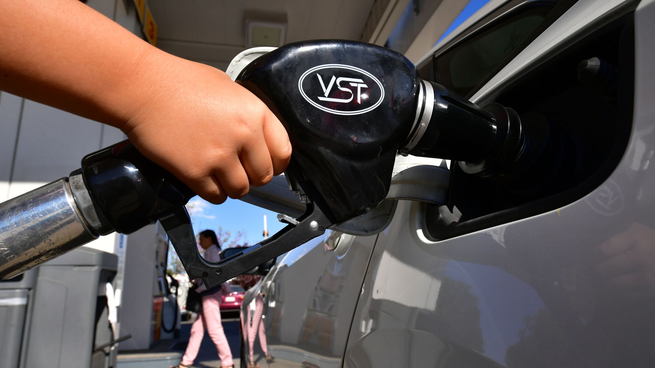 A child pumps gas for his father at a gas station in Los Angeles on April 9, 2019. (Credit: FREDERIC J. BROWN/AFP/Getty Images)