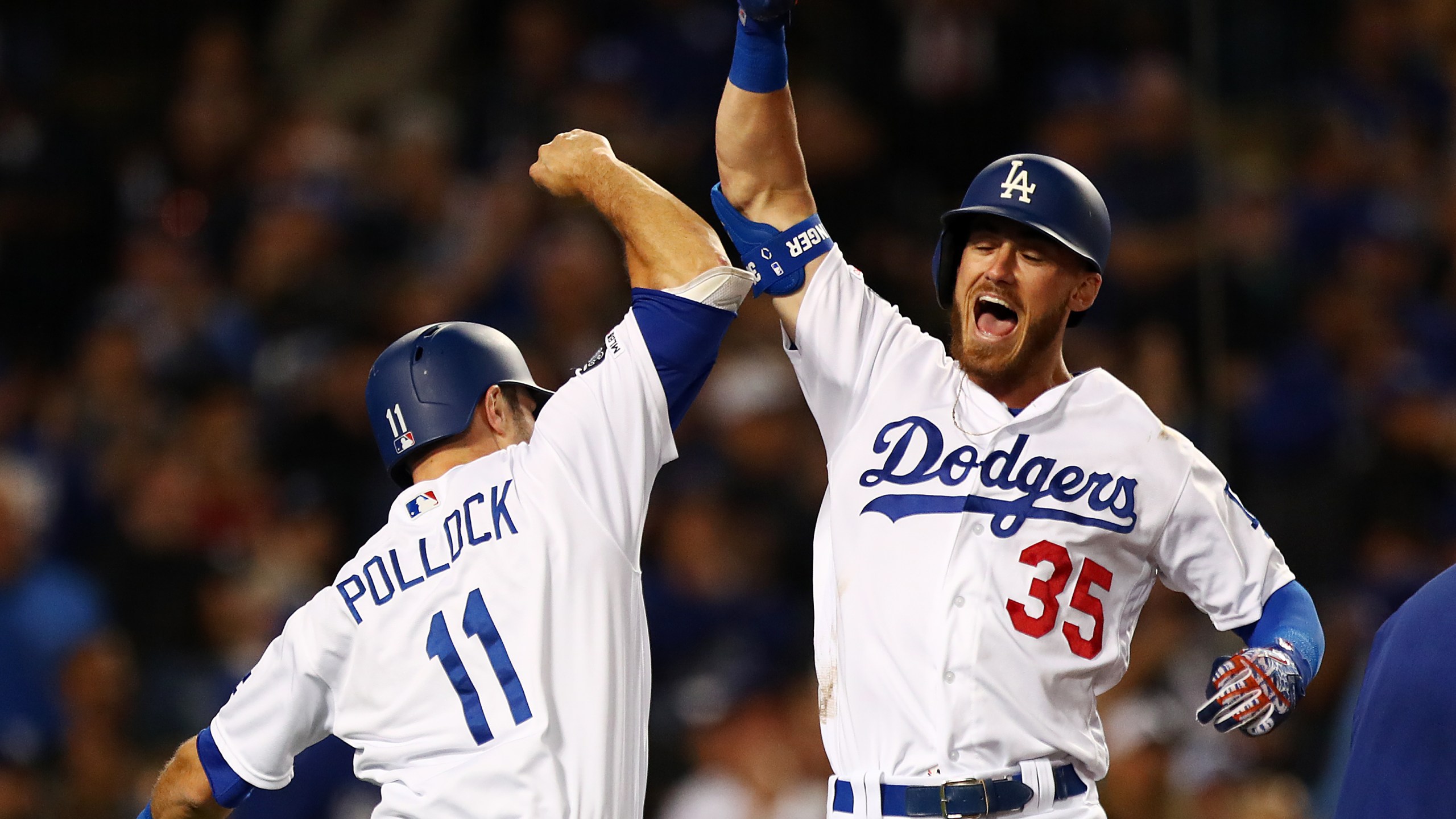 Cody Bellinger #35 of the Los Angeles Dodgers celebrates with A.J. Pollock #11 after hitting a grand slam against the San Francisco Giants during the third inning at Dodger Stadium on April 2, 2019. (Credit: Yong Teck Lim/Getty Images)