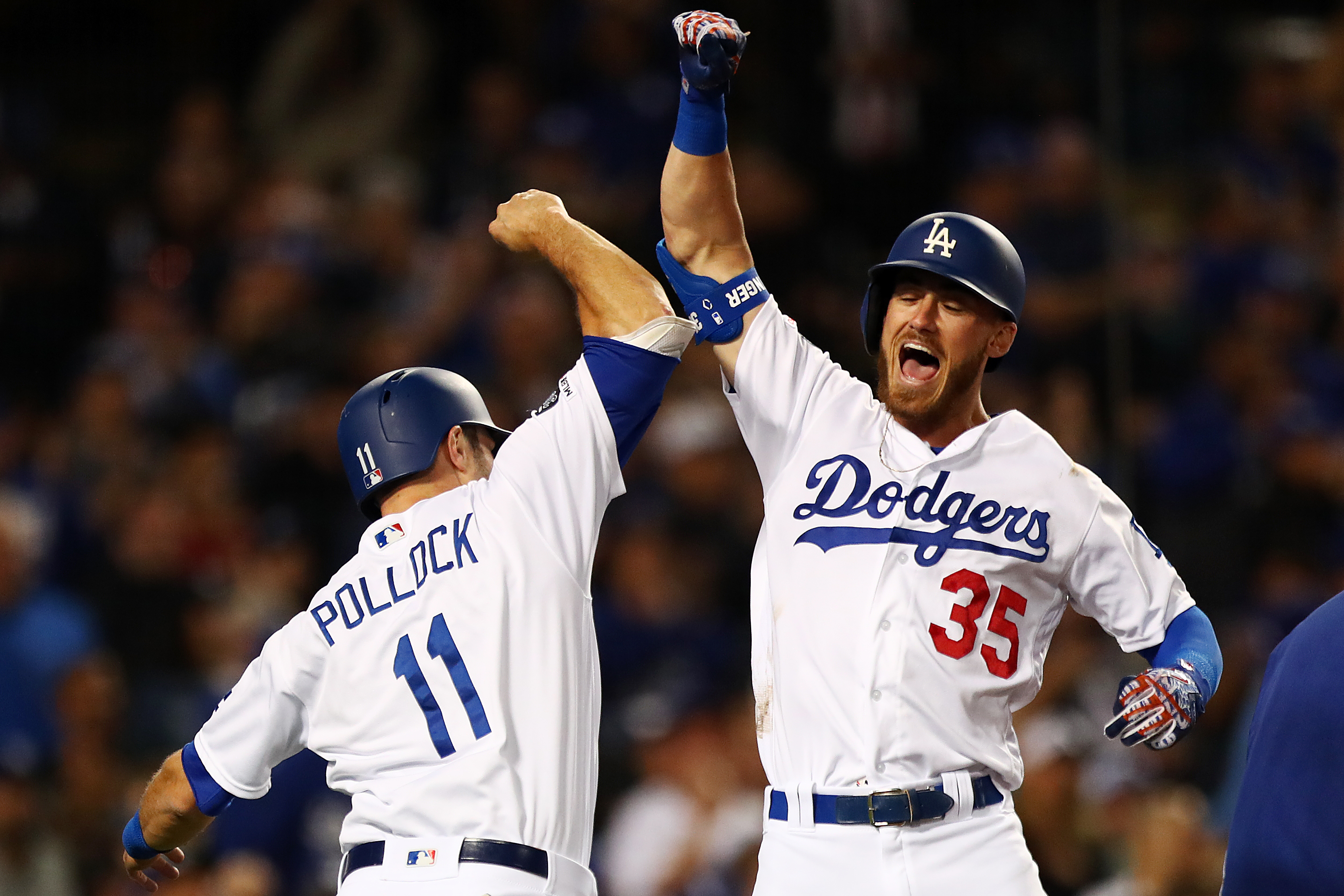 Cody Bellinger #35 of the Los Angeles Dodgers celebrates with A.J. Pollock #11 after hitting a grand slam against the San Francisco Giants during the third inning at Dodger Stadium on April 2, 2019. (Credit: Yong Teck Lim/Getty Images)