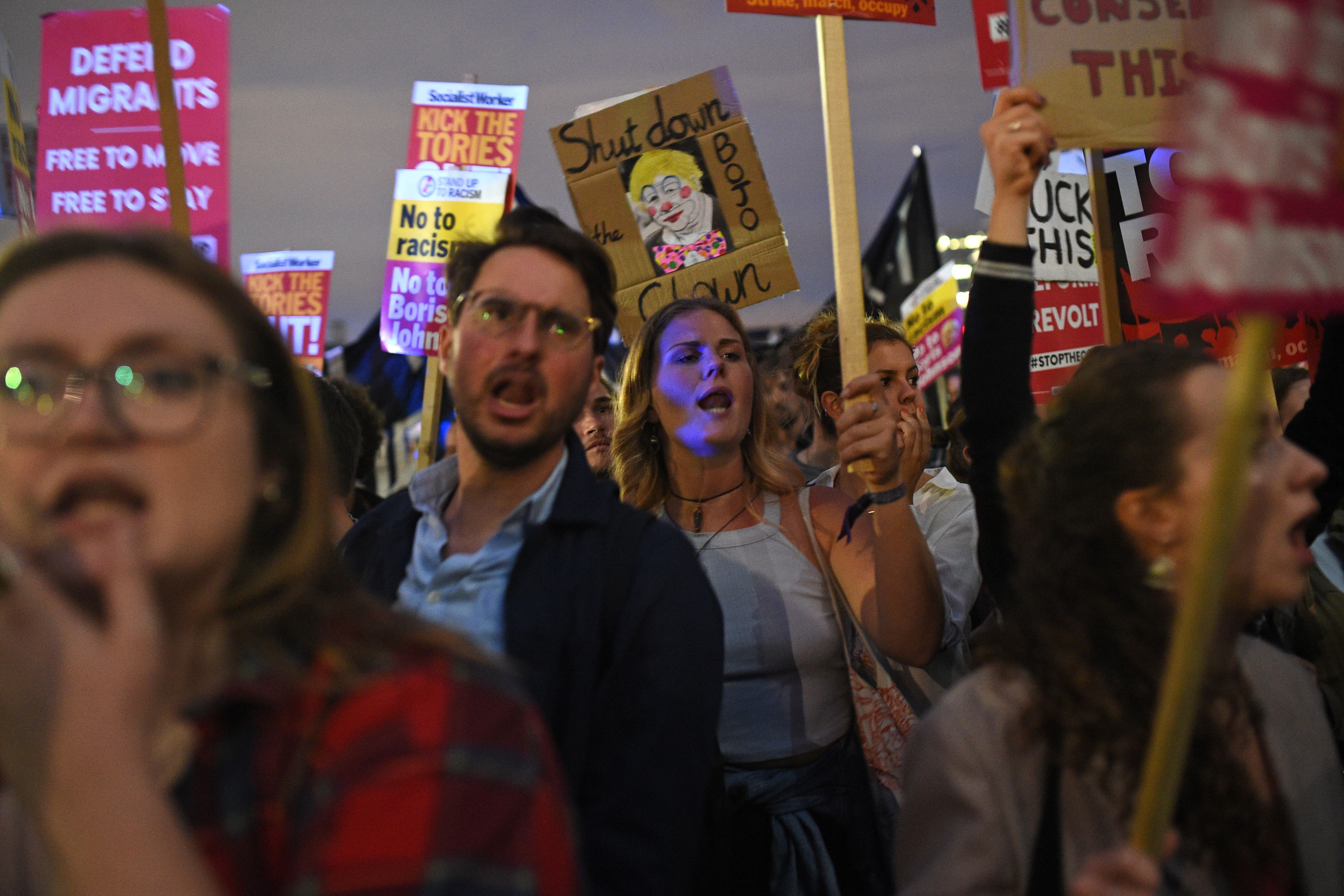 Demonstrators carry placards during a protest outside the Houses of Parliament in central London on Sept. 3, 2019, hosted by The People's Assembly Against Austerity. (Credit: Oli Scarff / AFP / Getty Images)