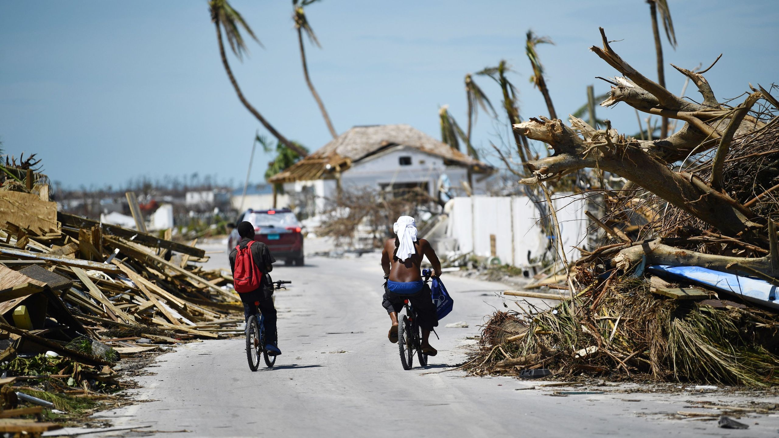 Residents pass damage caused by Hurricane Dorian on September 5, 2019, in Marsh Harbour, Great Abaco Island in the Bahamas. (Credit: BRENDAN SMIALOWSKI/AFP/Getty Images)