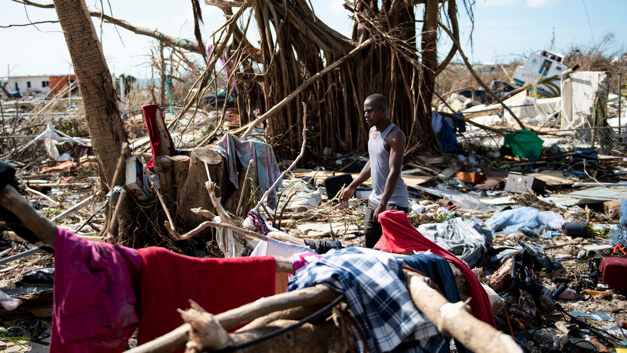 A man walks past damages caused by Hurricane Dorian on Sept. 5, 2019, in Marsh Harbour, Great Abaco Island in the Bahamas. (Credit: BRENDAN SMIALOWSKI/AFP/Getty Images)