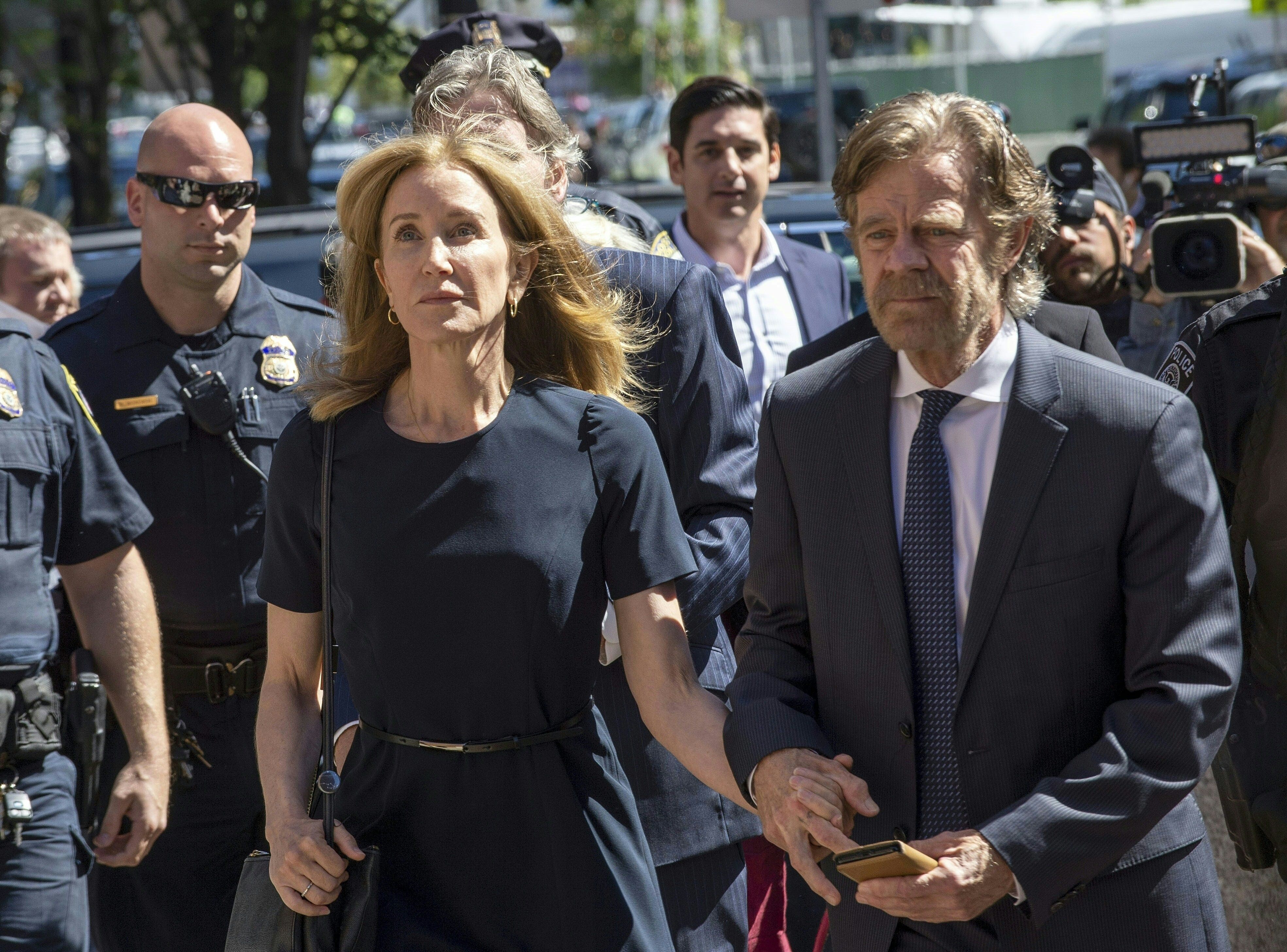 Actress Felicity Huffman, escorted by her husband William H. Macy, makes her way to the entrance of the John Joseph Moakley United States Courthouse in Boston on Sept. 13, 2019. (Credit: JOSEPH PREZIOSO/AFP/Getty Images)