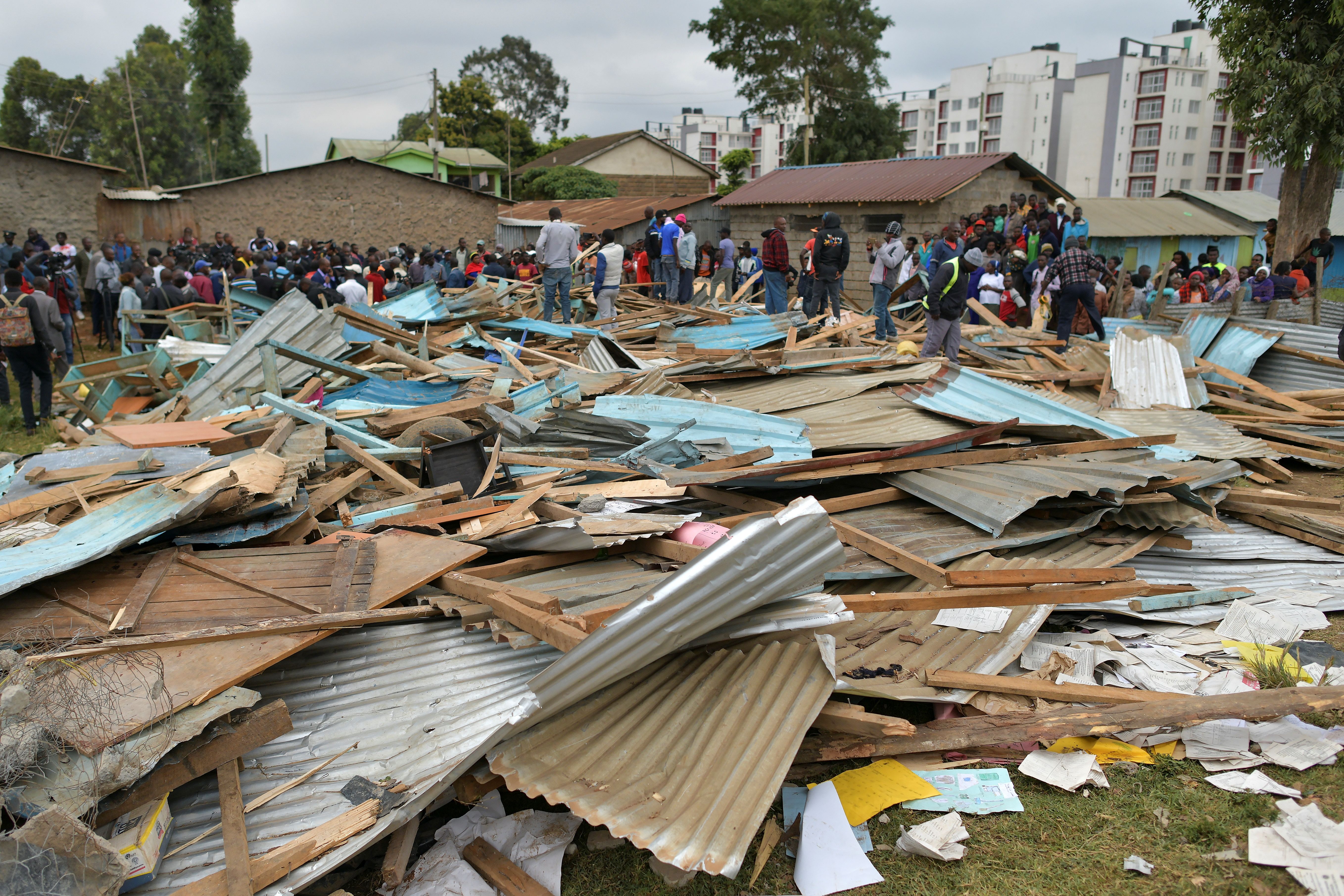 Relatives stand on debris of a collapsed school building, on September 23, 2019 in Nairobi. (Credit: TONY KARUMBA/AFP/Getty Images)