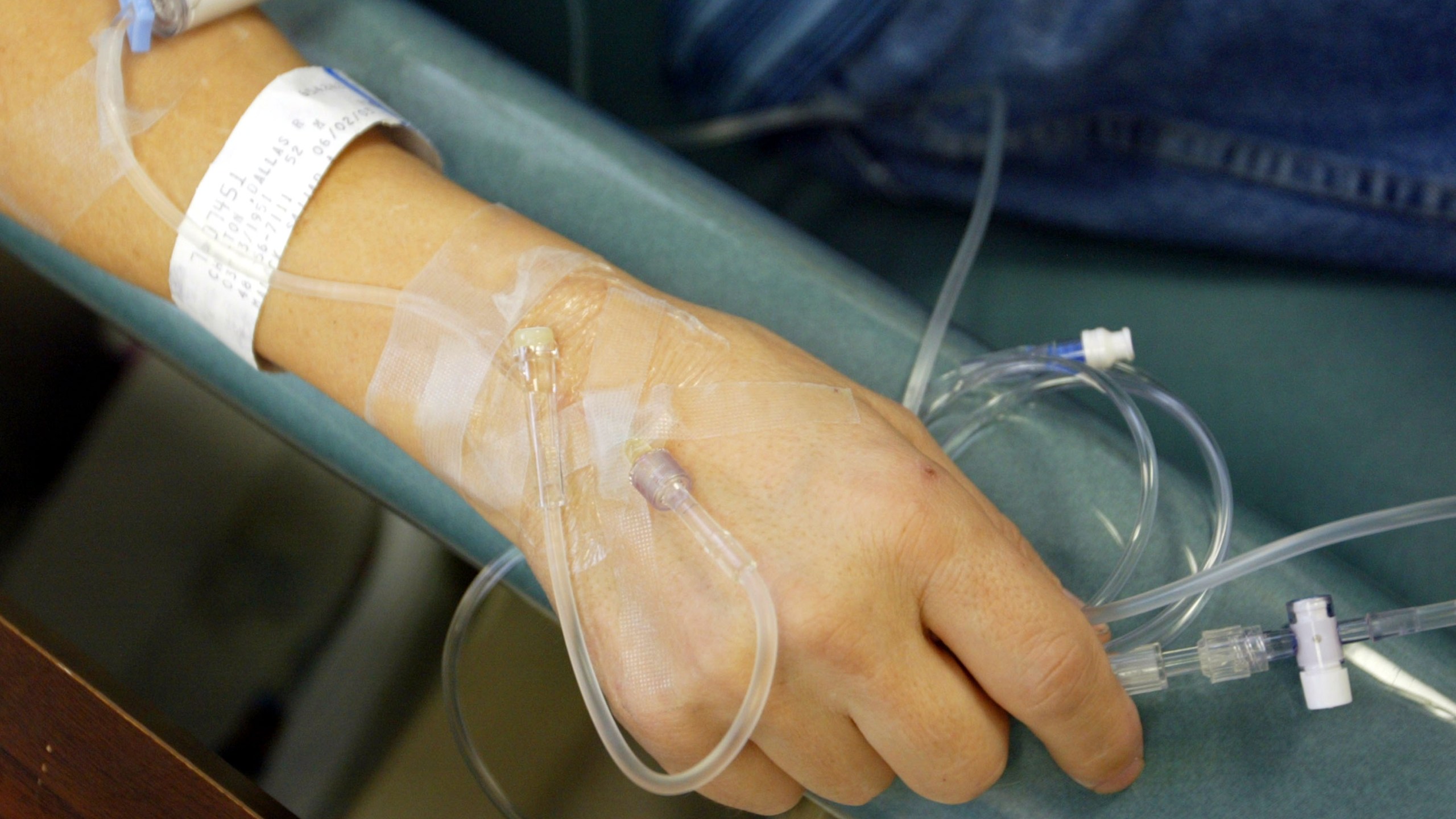 A cancer patient holds the tubes that funnel chemotherapy drugs into his body in this file photo. (Credit: Chris Hondros/Getty Images)