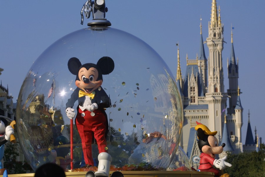 Mickey Mouse rides in a parade through Main Street with Cinderella's castle in the background at Disney World's Magic Kingdom in Orlando on Nov. 11, 2001. (Joe Raedle / Getty Images)