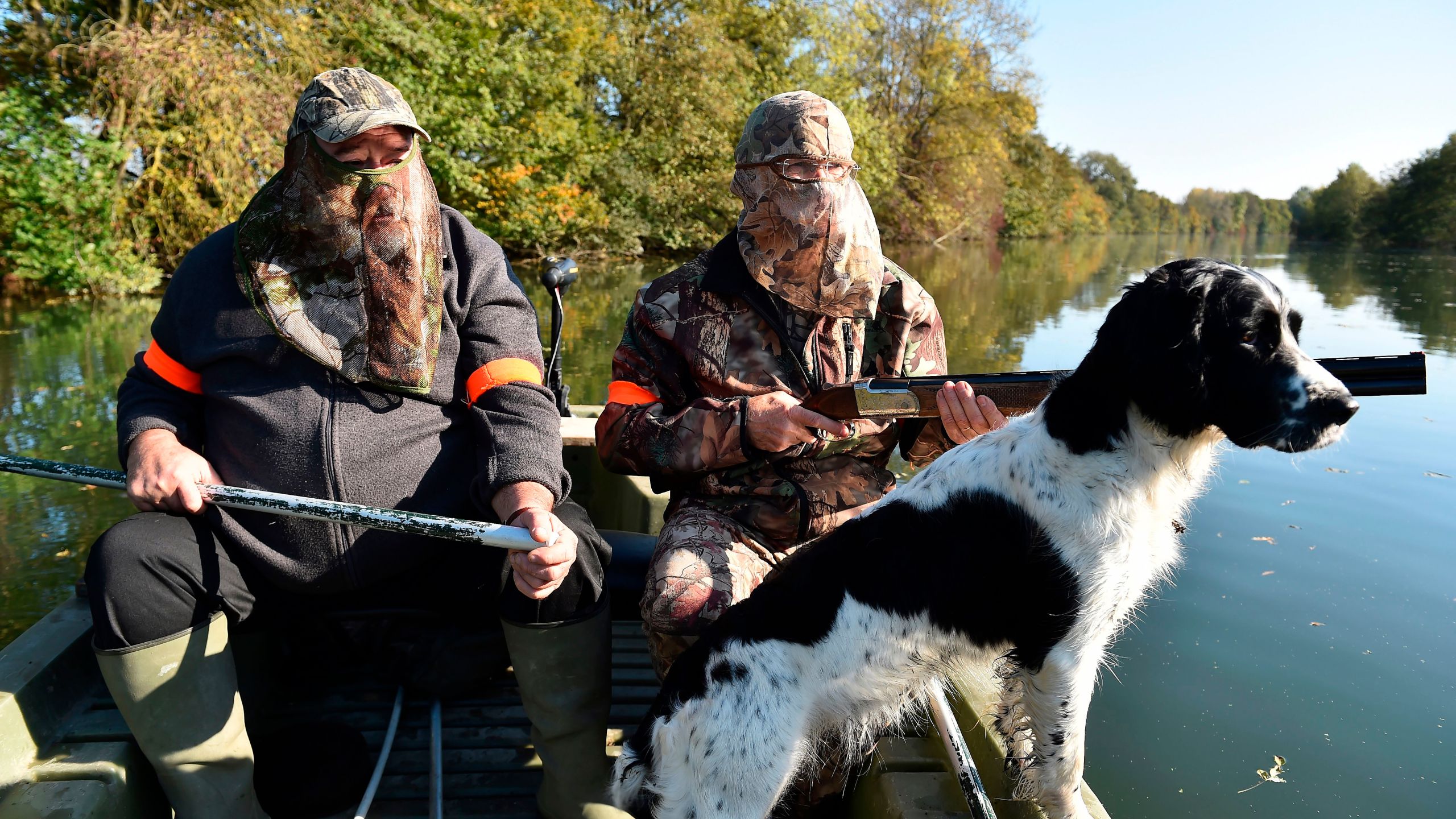 Waterfowl hunters with their Springer Spaniel dog, steer a boat on Le Loir river, during a duck hunting in Vaas, France, on Oct. 15, 2017. (Credit: JEAN-FRANCOIS MONIER/AFP/Getty Images)