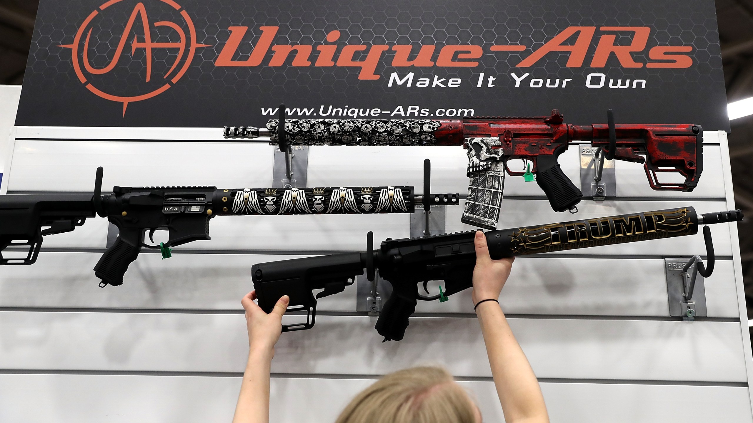 A vendor hangs an AR-15 rifle with a custom "Trump - Make America Great Again" hand guard at the Unique ARs booth during the NRA Annual Meeting & Exhibits at the Kay Bailey Hutchison Convention Center on May 5, 2018 in Dallas, Texas. (Credit: Justin Sullivan/Getty Images)