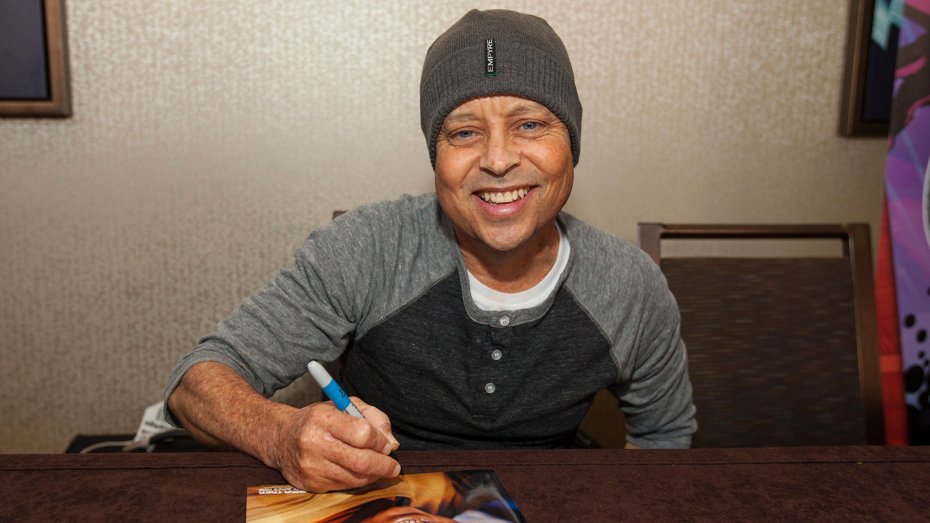 Actor Aron Eisenberg signs an autograph at a Star Trek convention in 2014. (Credit: Barry Brecheisen/Invision/AP)