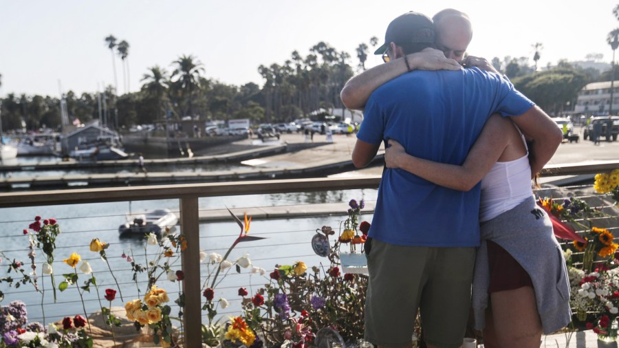 People embrace at Santa Barbara Harbor at a makeshift memorial for victims of the Conception boat fire on Sept. 3, 2019 in Santa Barbara. (Credit: Mario Tama/Getty Images)