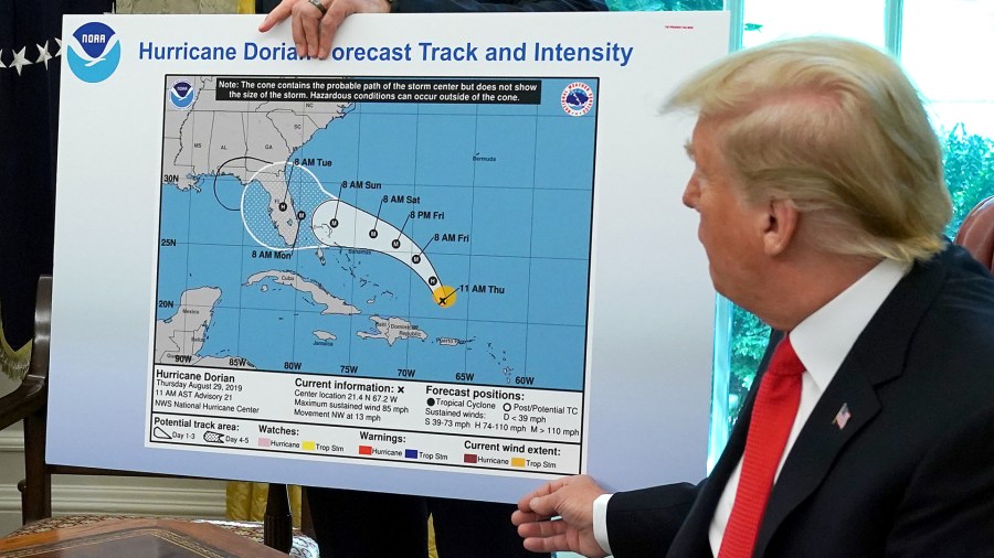 U.S. President Donald Trump (R) references a map held by acting Homeland Security Secretary Kevin McAleenan while talking to reporters following a briefing from officials about Hurricane Dorian in the Oval Office at the White House September 04, 2019 in Washington, DC. The map was a forecast from August 29 and appears to have been altered by a black marker to extend the hurricane's range to include Alabama. (Credit: Chip Somodevilla/Getty Images)