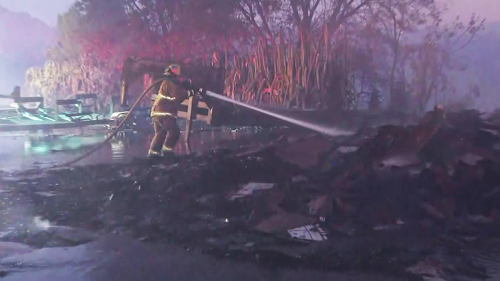 A firefighter battling the 46 Fire douses some burning material on Oct. 31, 2019. (Credit: KTLA)