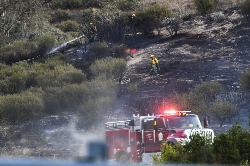 Firefighters put out a hot spot while battling the Old Water Fire in San Bernardino on Oct. 24, 2019. (Credit: Irfan Khan/Los Angeles Times)