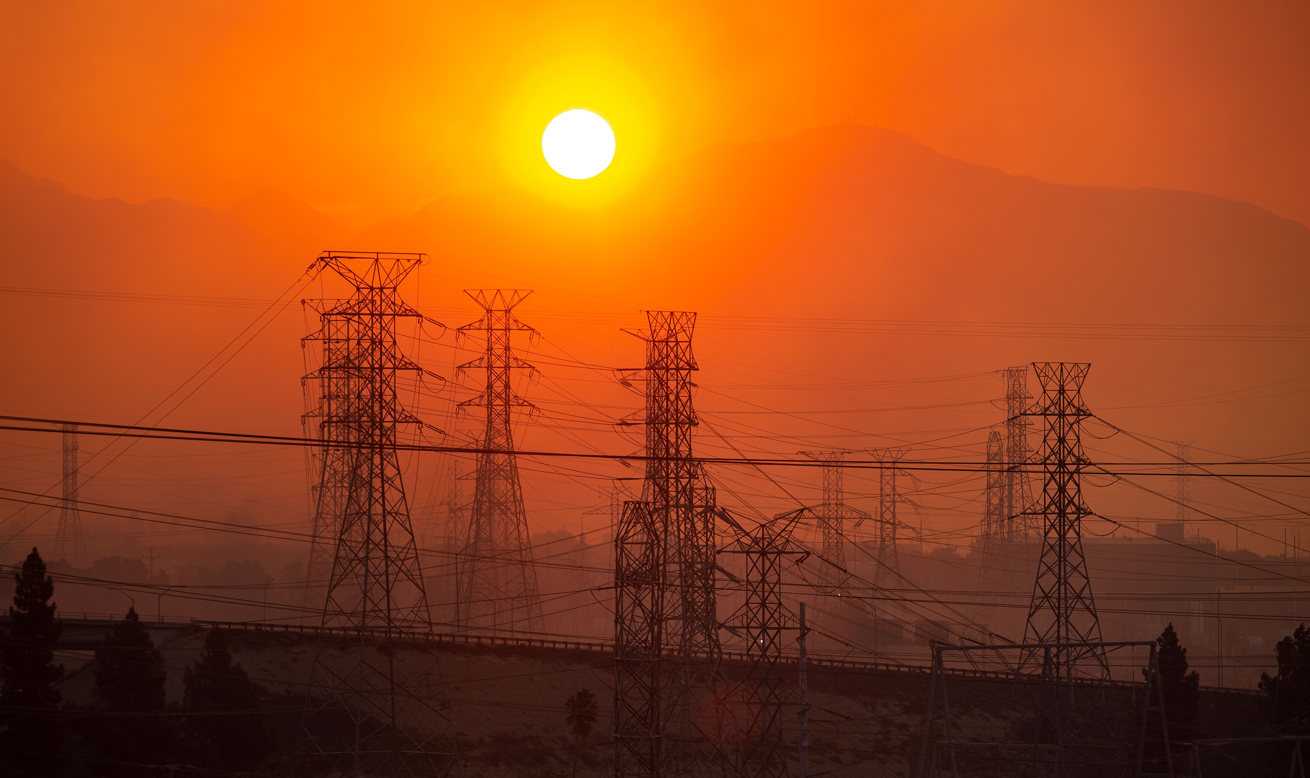 The sun rises over power lines along a smokey horizon during the Saddleridge Fire in Newhall on Oct. 11, 2019. (Credit: Josh Edelson/AFP via Getty Images)