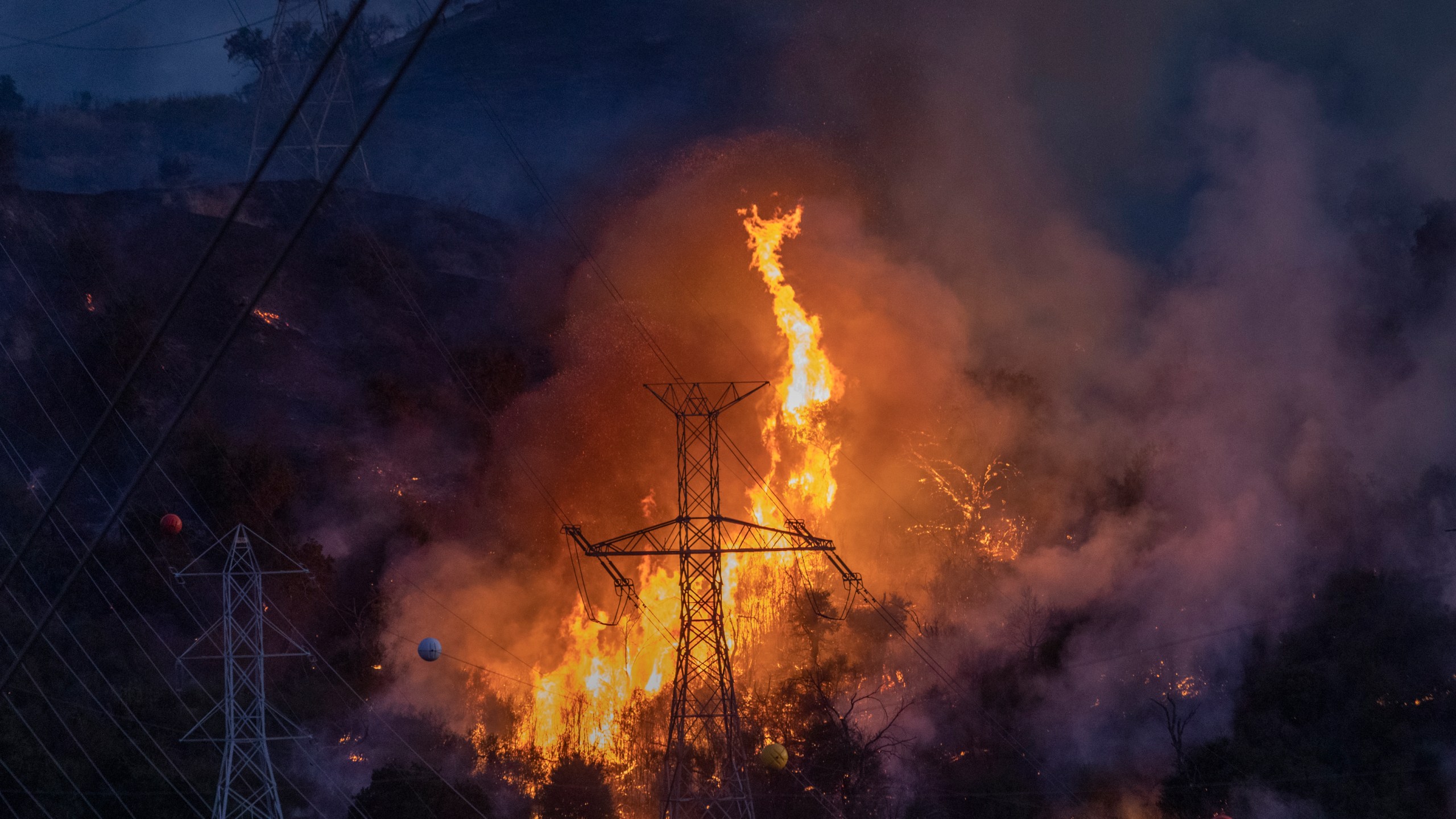 Flames heat up high power lines at the Saddleridge Fire on Oct. 11, 2019, near Newhall. (Credit: David McNew/Getty Images)