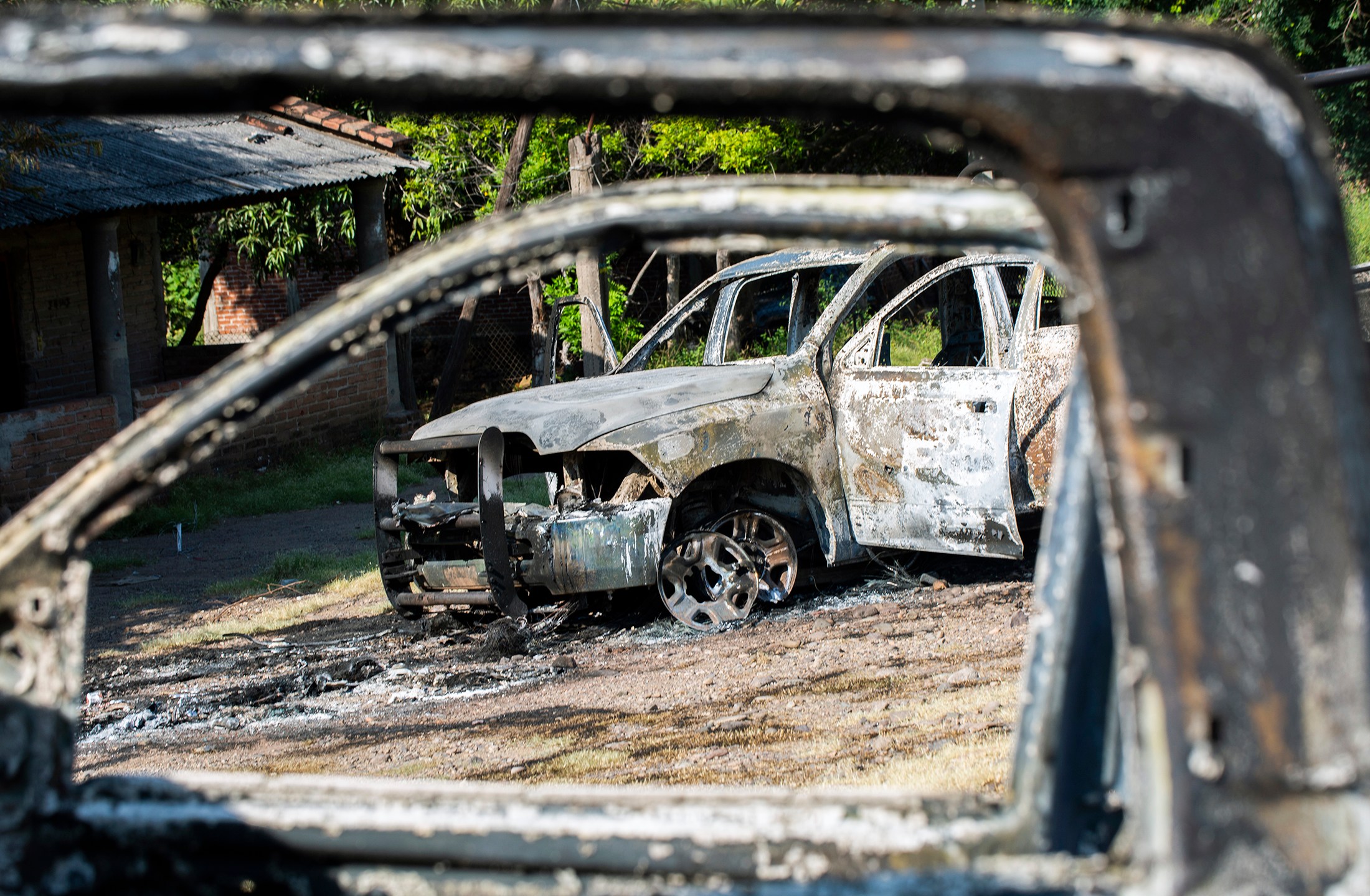 Police vehicles are seen after being torched by gunmen who also killed 14 officers in an ambush in the community of Aguililla, in the Mexican state of Michoacan, on Oct. 14, 2019. (Credit: Enrique Castro / AFP / Getty Images)