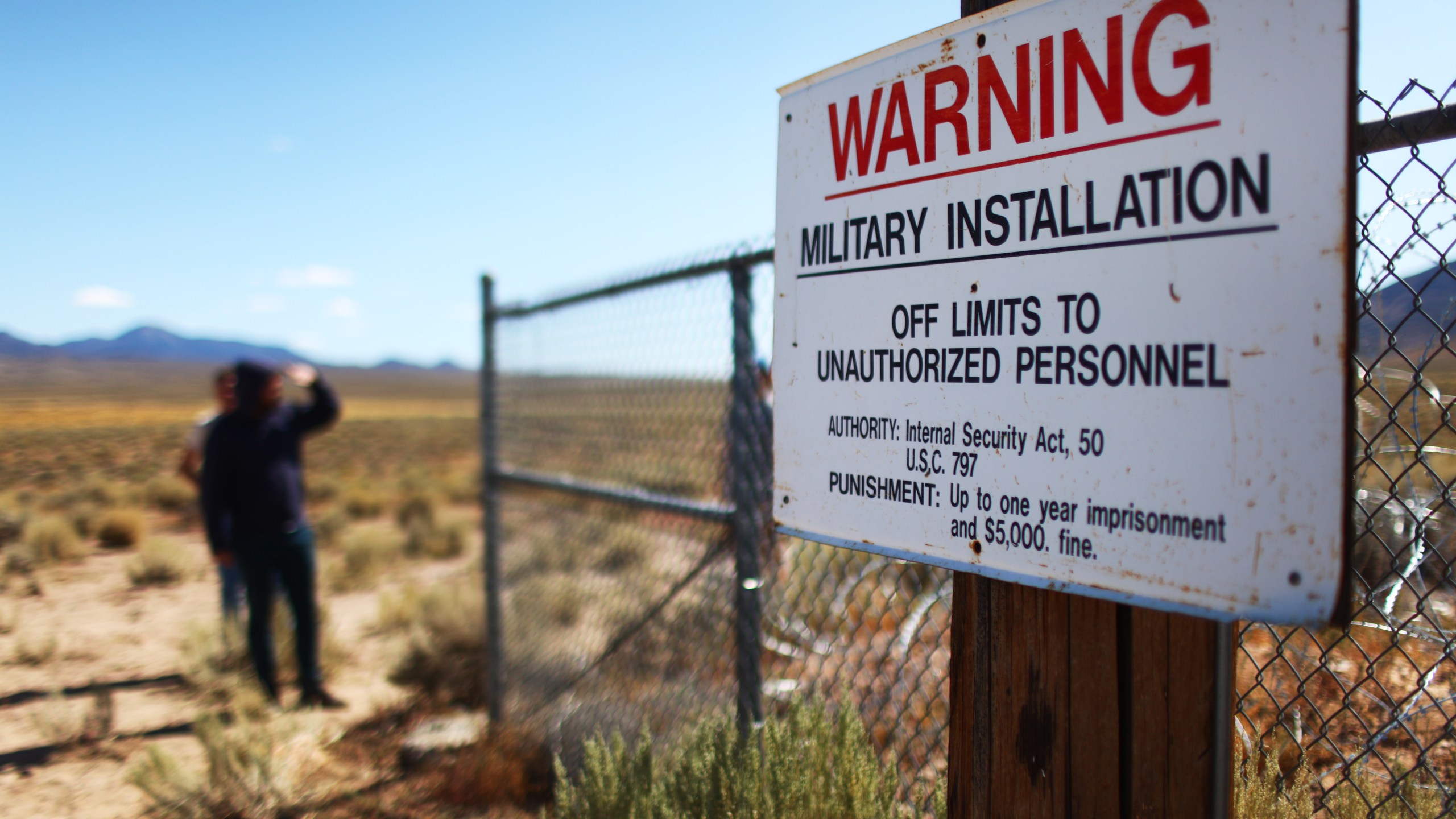 People gather at an entrance gate to the Nevada Test and Training Range, the official name for the facility containing what is known as Area 51, near Rachel, Nevada, on Sept. 20, 2019. (Credit: Mario Tama / Getty Images)