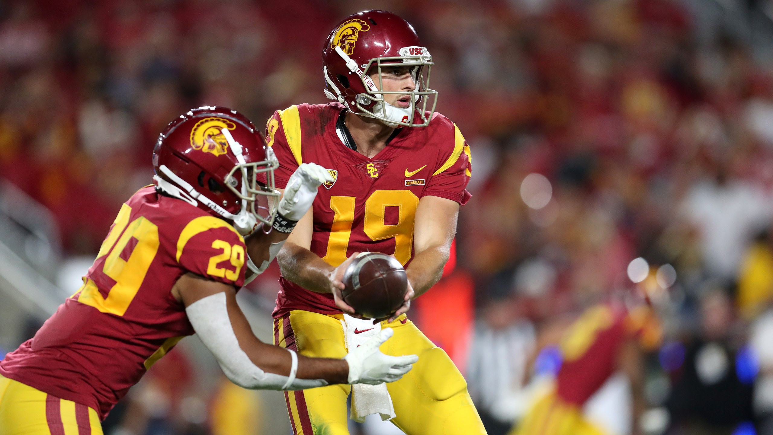 Matt Fink, No. 19, of the USC Trojans hands off to teammate Vavae Malepeai, No. 29, during a match against the Utah Utes at Los Angeles Memorial Coliseum on Sept. 20, 2019. (Credit: Meg Oliphant/Getty Images)