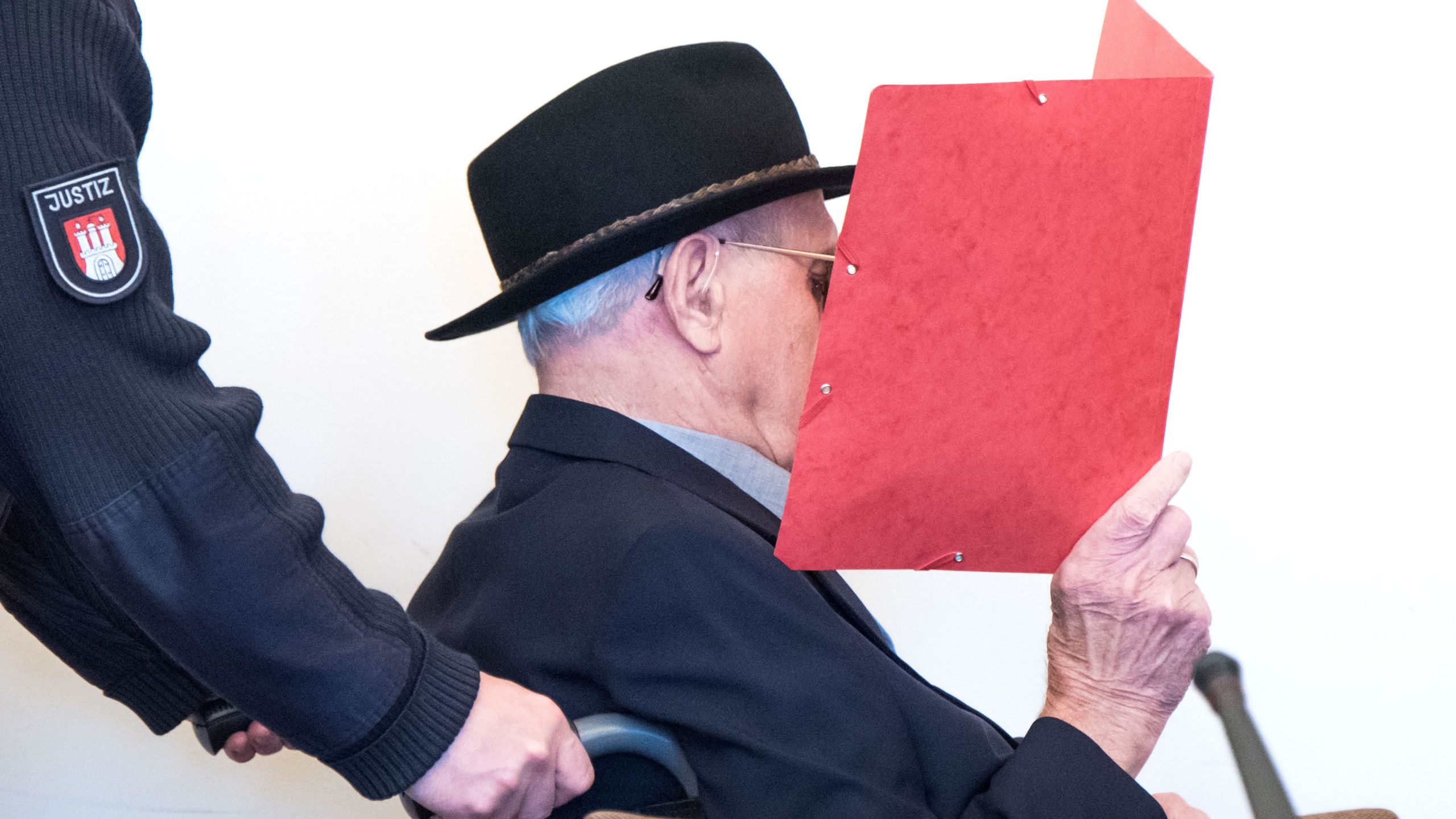 93-year-old former SS guard Bruno Dey covers his face as he arrives in the courtroom in Hamburg, on October 17, 2019. (Credit: DANIEL BOCKWOLDT/POOL/AFP via Getty Images)