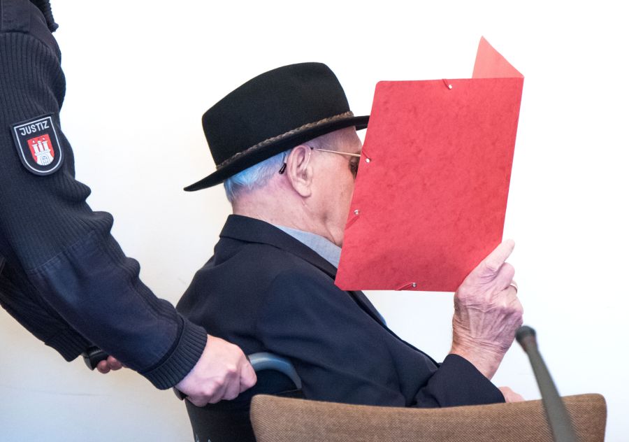 93-year-old former SS guard Bruno Dey covers his face as he arrives in the courtroom in Hamburg, on October 17, 2019. (Credit: DANIEL BOCKWOLDT/POOL/AFP via Getty Images)