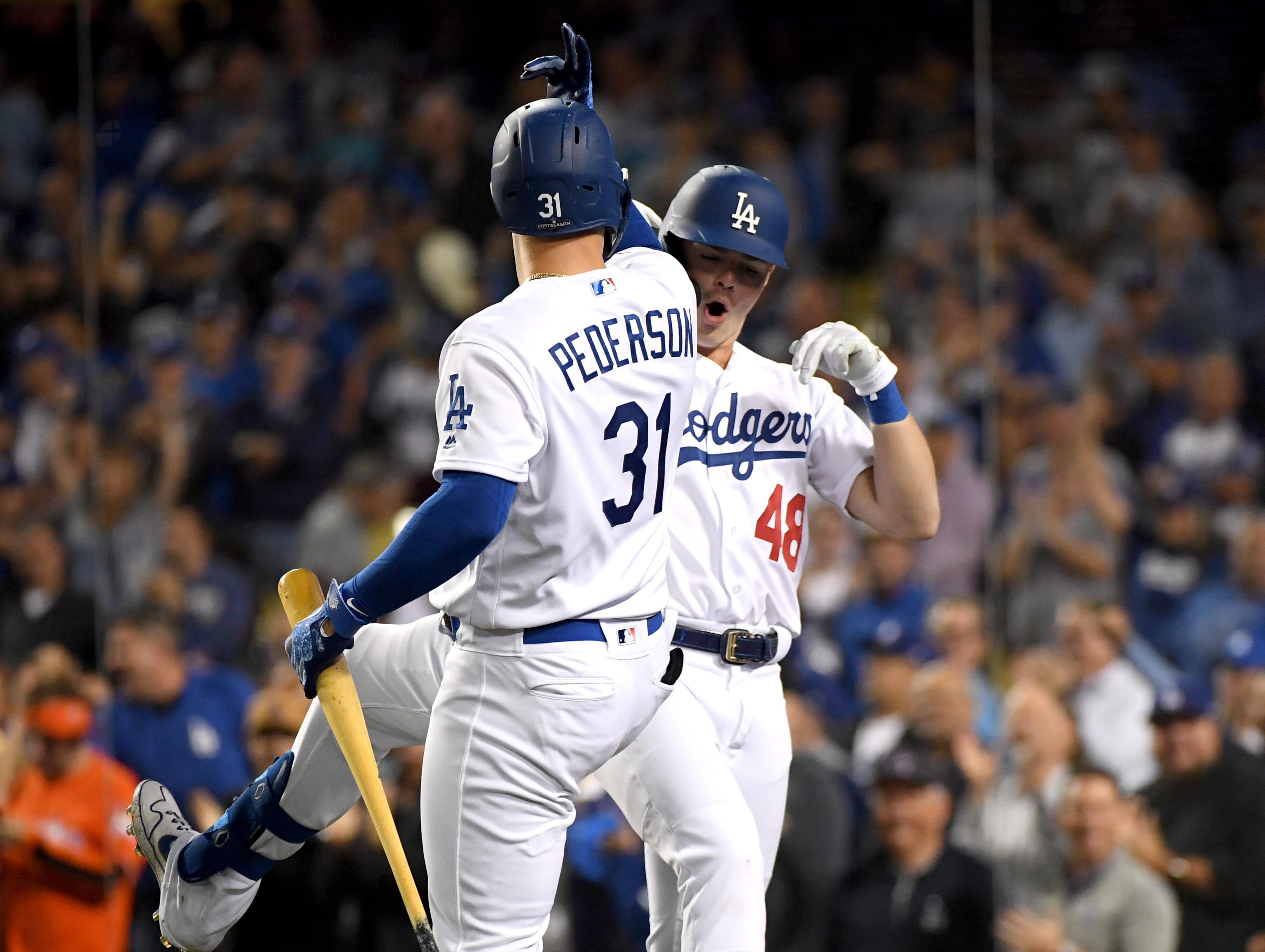 Gavin Lux of the Los Angeles Dodgers, right, celebrates his solo home run with teammate Joc Pederson in the eighth inning of game one of the National League Division Series against the Washington Nationals at Dodger Stadium on Oct. 3, 2019. (Credit: Harry How / Getty Images)