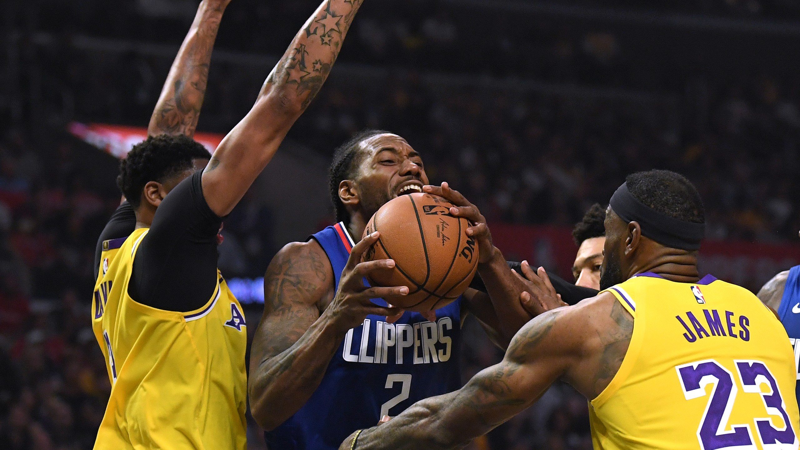 Kawhi Leonard of the L.A. Clippers is fouled by LeBron James of the L.A. Lakers as he steps by Anthony Davis during a game at Staples Center on Oct. 22, 2019. (Credit: Harry How/Getty Images)