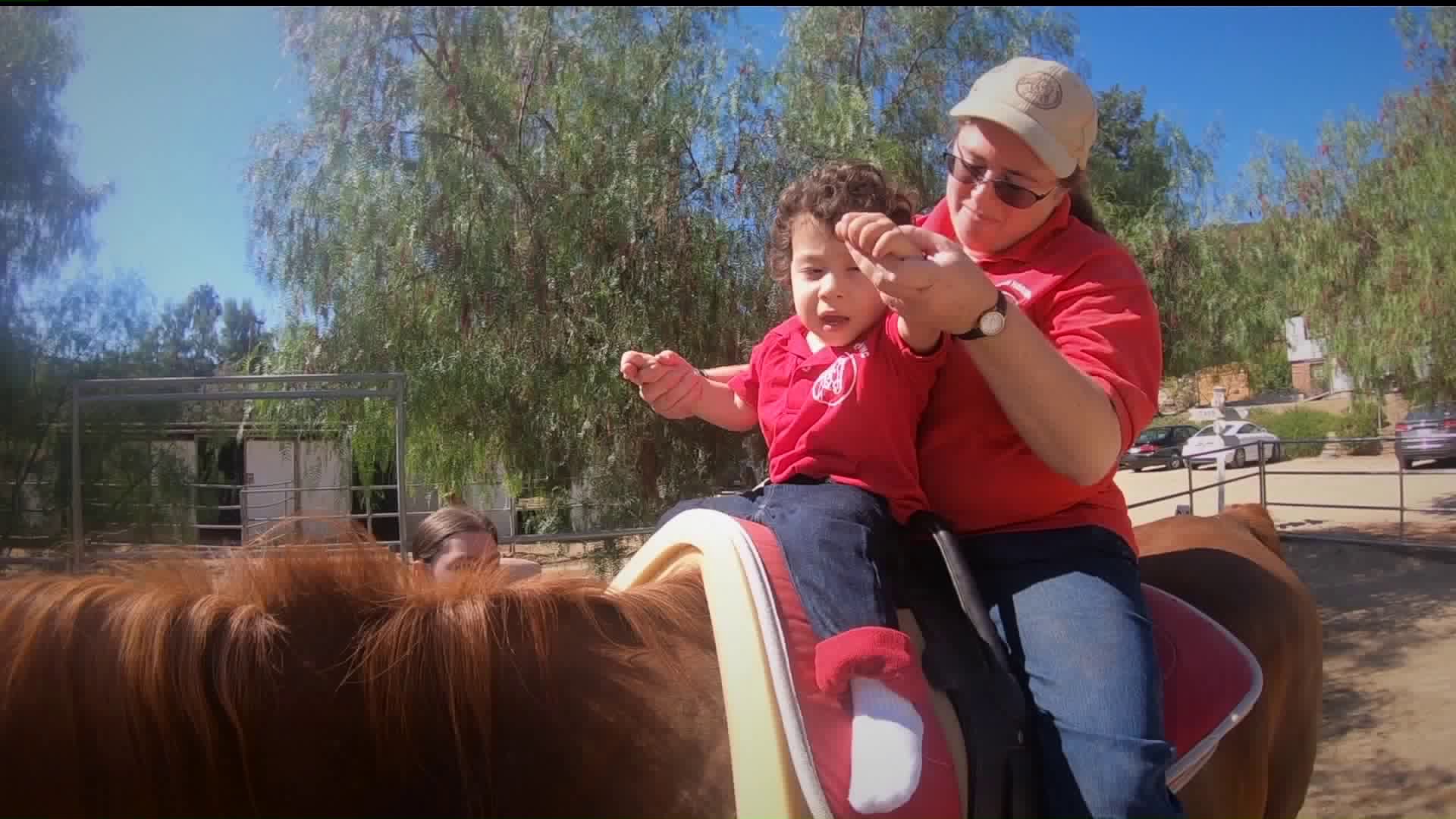 A young patient receives equine therapy at Ahead with Horses in Shadow Hills on Oct. 3, 2019. (Credit: KTLA)