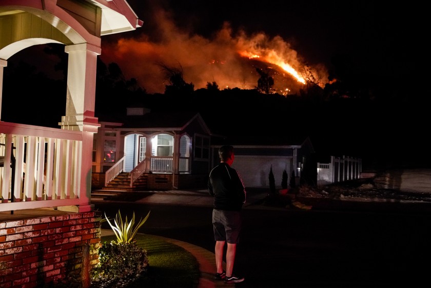 Oakridge Estates resident Manuel Negrete gazes at the Saddleridge fire as his neighbors evacuate on Oct. 10, 2019. (Credit: Kent Nishimura / Los Angeles Times)