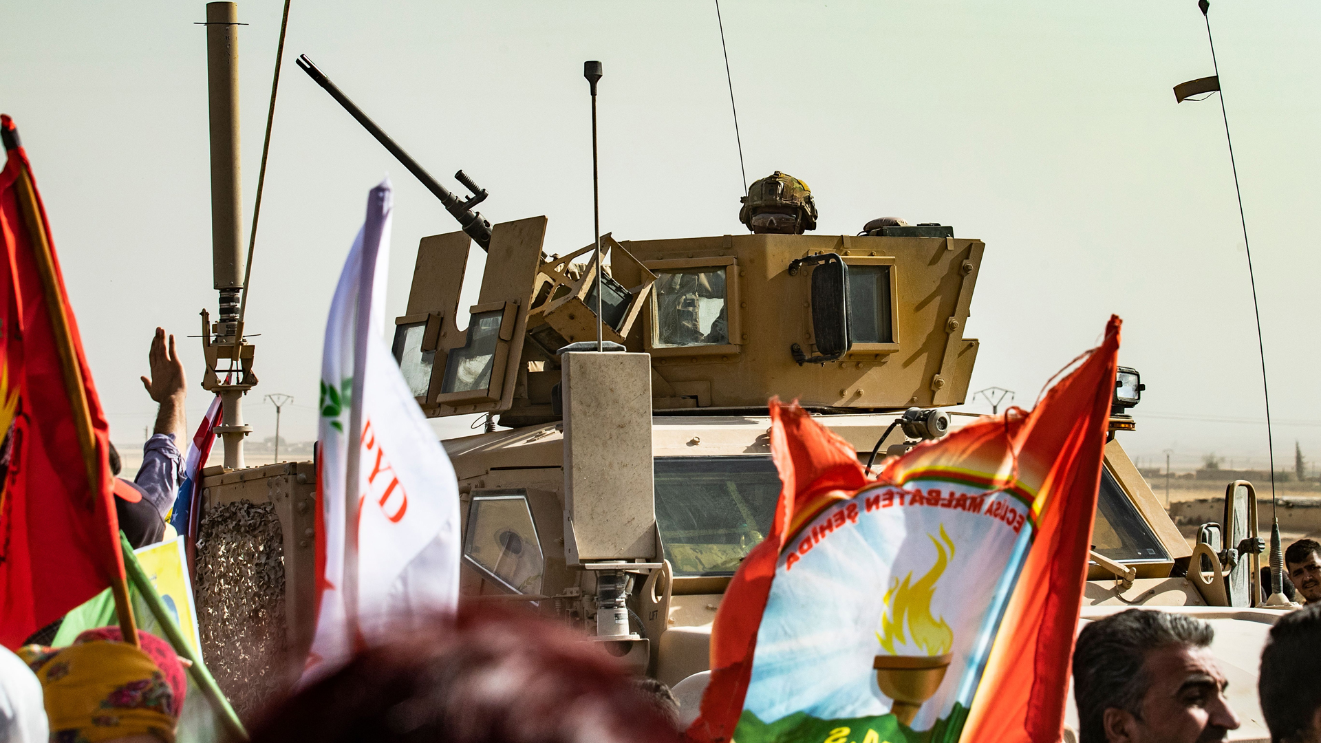 A soldier sits atop an armored vehicle during a demonstration by Syrian Kurds against Turkish threats at a US-led international coalition base on the outskirts of Ras al-Ain town in Syria's Hasakeh province near the Turkish border on October 6, 2019. - Ankara had reiterated on October 5 an oft-repeated threat to launch an "air and ground" operation in Syria against a Kurdish militia it deems a terrorist group. (Credit: Delil Souleiman/AFP/Getty Images)