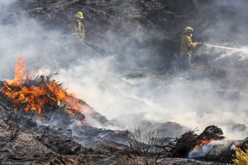 Firefighters battle the Tick fire along Sierra Highway in Santa Clarita on Oct. 25, 2019. (Credit: Irfan Khan/Los Angeles Times)