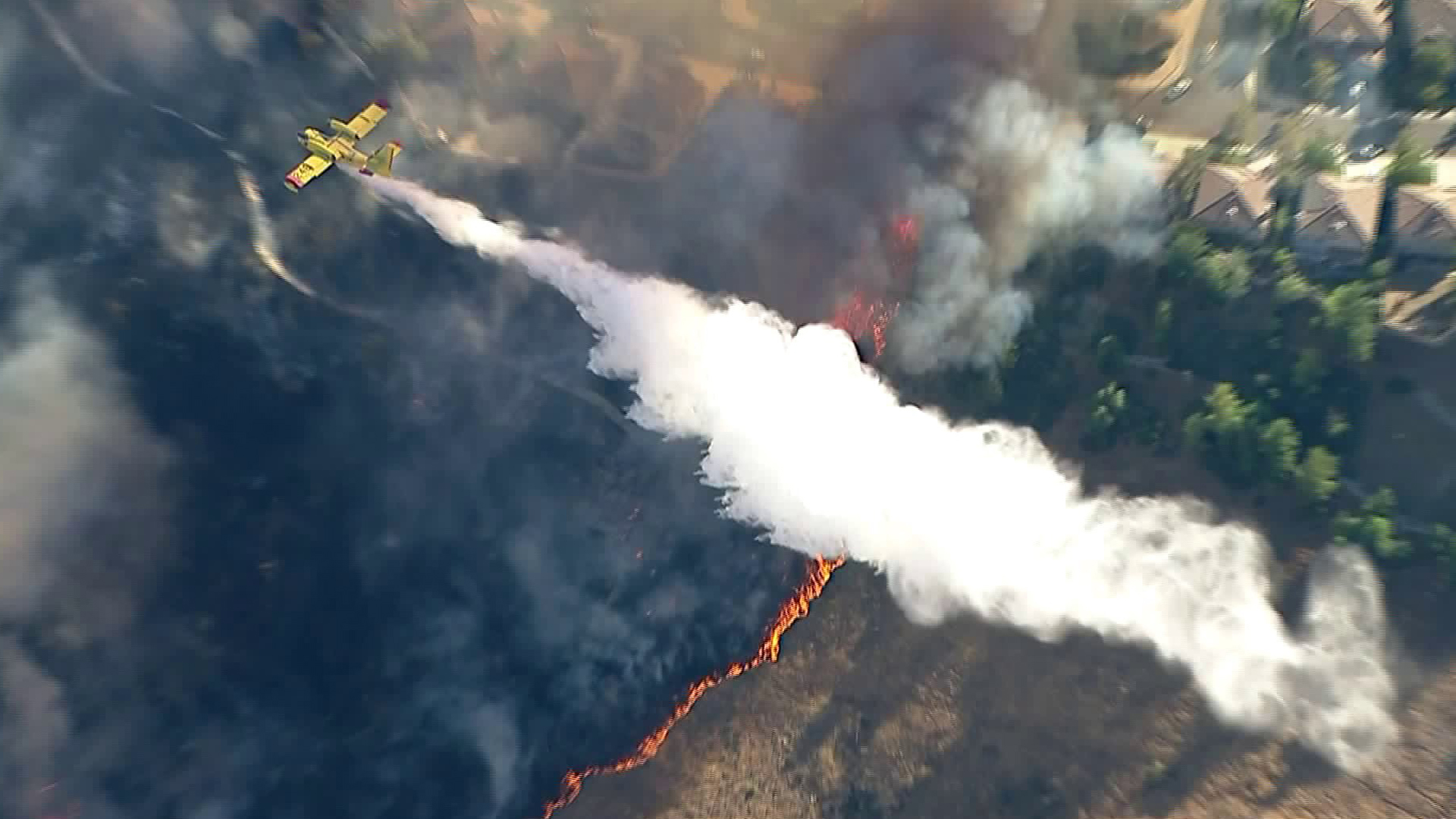 A Superscooper makes a water drop on threatened homes in the Old Fire on Oct. 24, 2019. (Credit: KTLA)