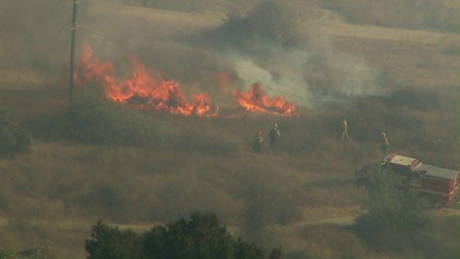 Firefighters work to extinguish a brush fire in Whittier Narrows on Oct. 21, 2019. (Credit: KTLA)