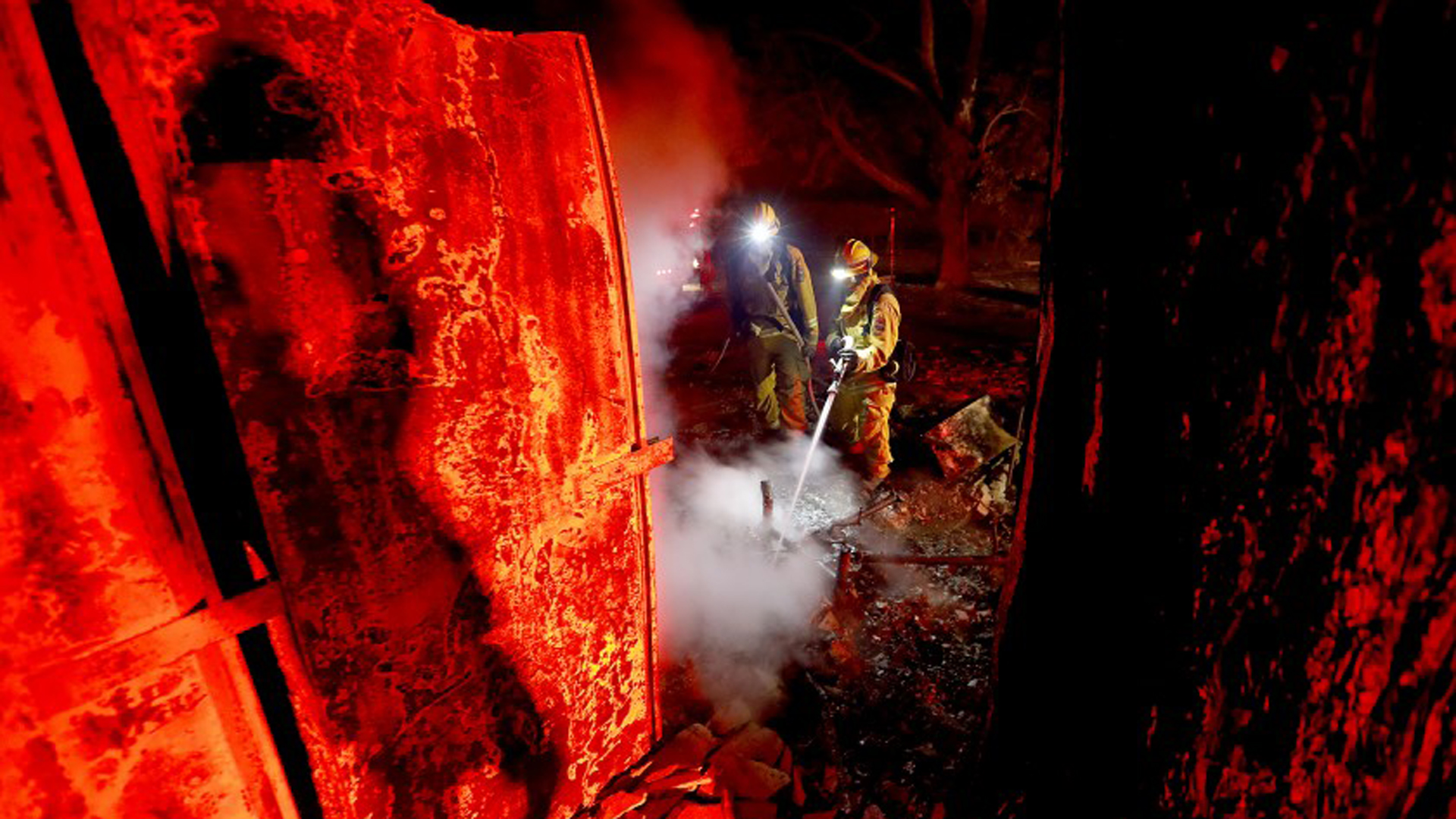 Firefighters mop up hot spots at two homes along Red Wine Road in Geyserville, Calif., that burned in the Kincade fire in the early morning of Oct. 25, 2019. (Credit: Luis Sinco / Los Angeles Times)