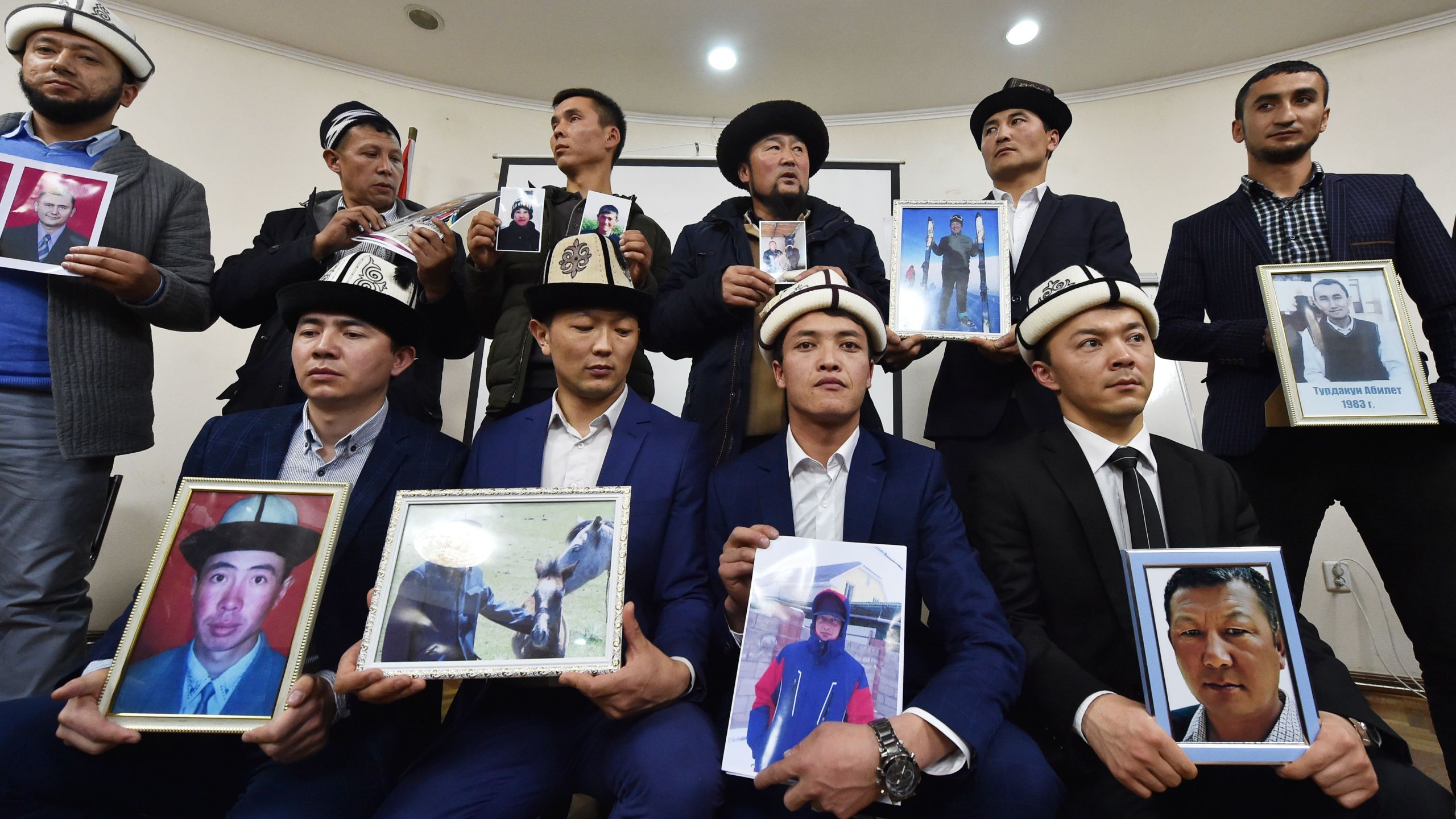 People attend a press conference in Bishkek, Kyrgyzstan on Nov. 29, 2018 holding portraits of their relatives they fear are being held in "reeducation camps" in China's Xinjiang region. (Credit: VYACHESLAV OSELEDKO/AFP via Getty Images)