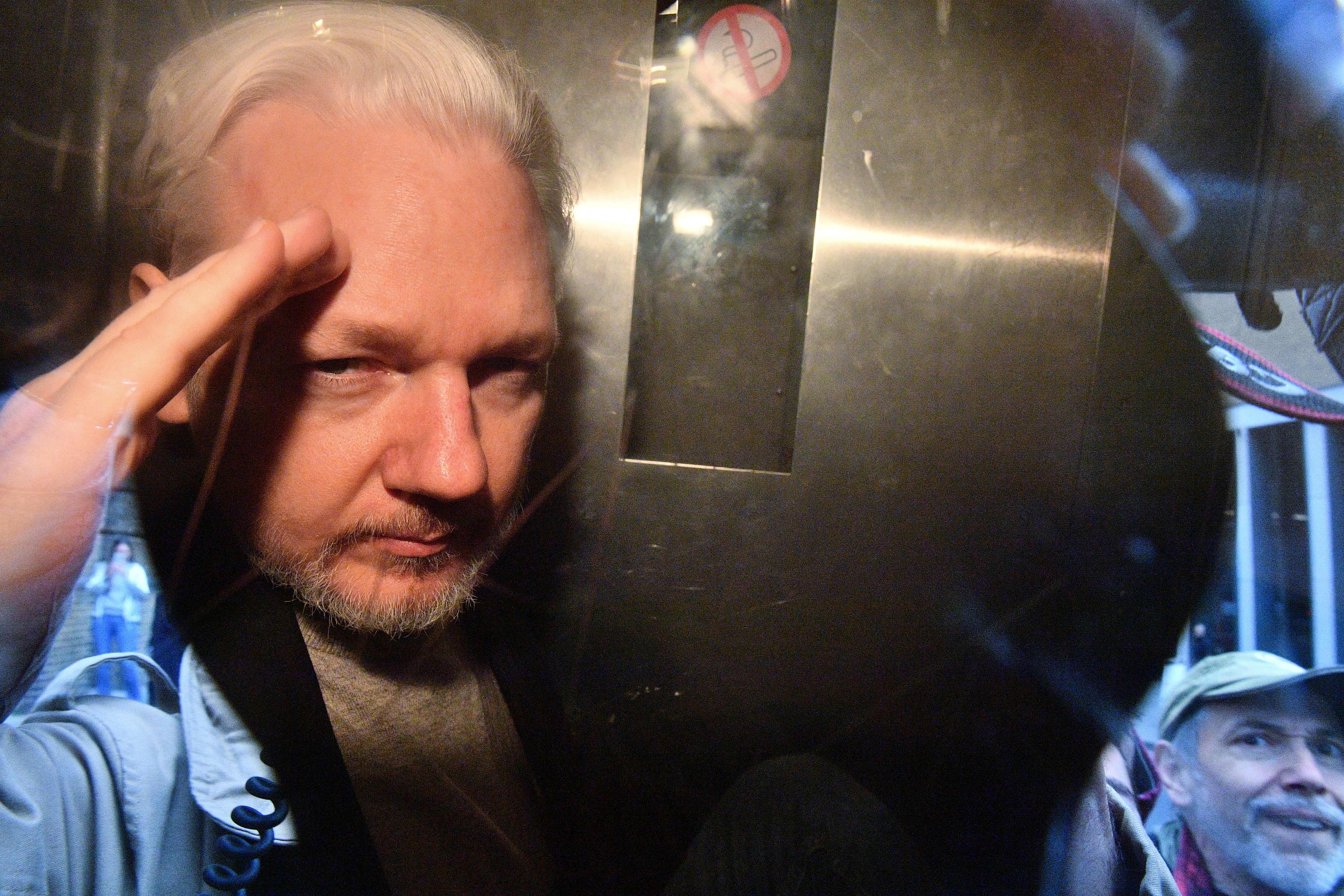 WikiLeaks founder Julian Assange gestures from the window of a prison van as he is driven out of Southwark Crown Court in London on May 1, 2019. (Credit: DANIEL LEAL-OLIVAS/AFP via Getty Images)