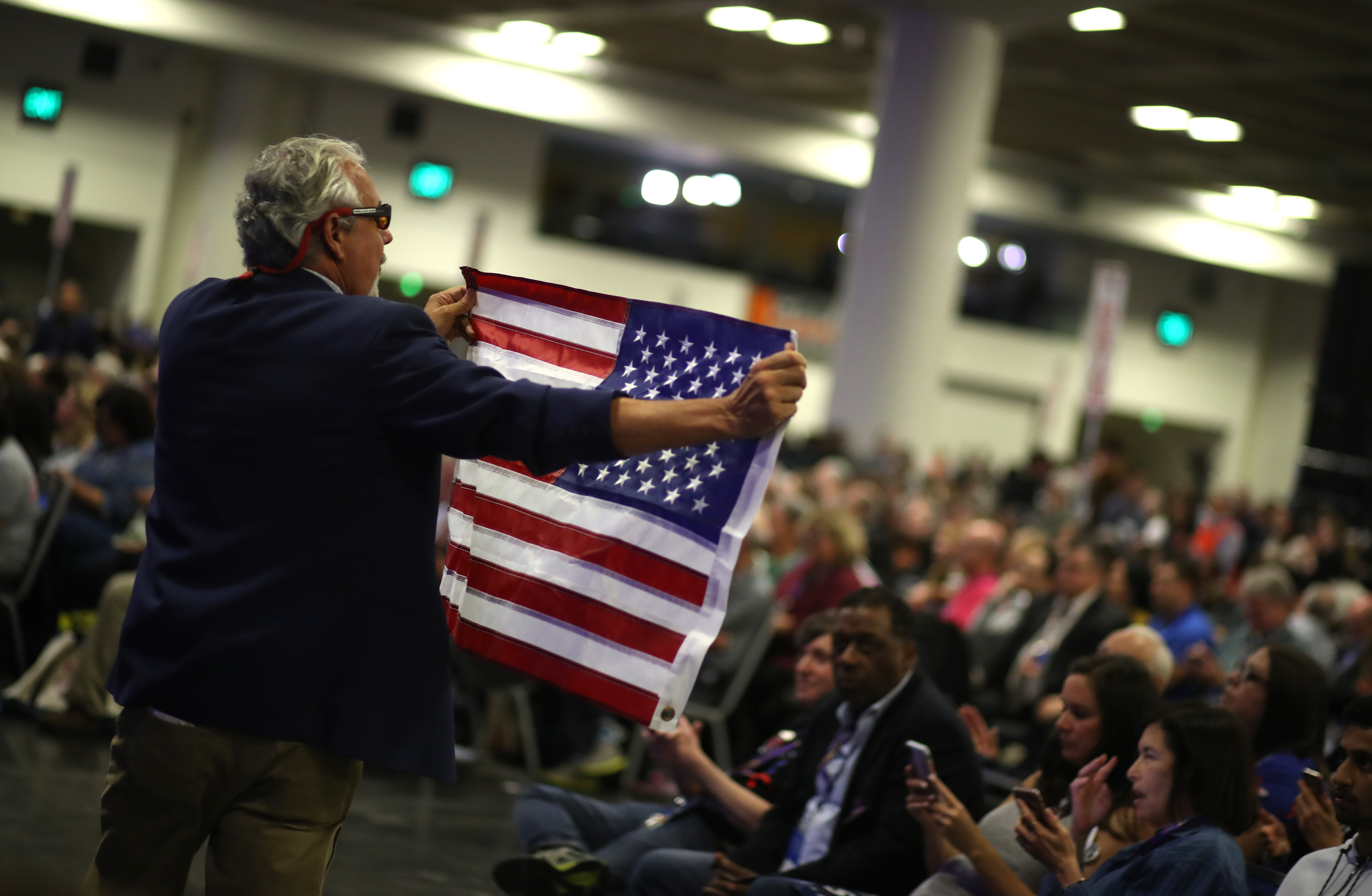 An attendee carries an American flag during the California Democrats 2019 State Convention at the Moscone Center on June 1, 2019, in San Francisco. (Credit: Justin Sullivan/Getty Images)