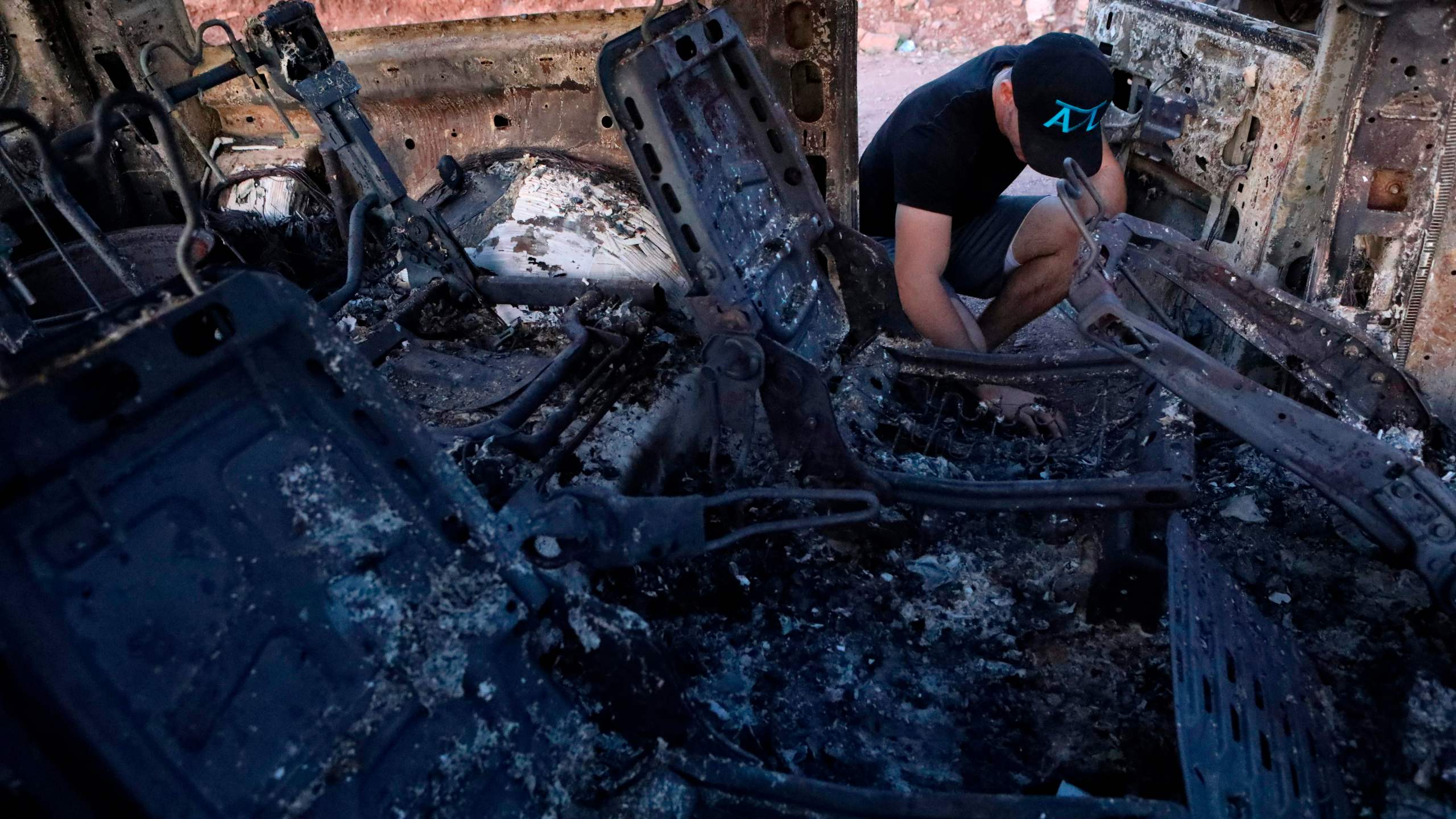 A member of thA member of the LeBaron family looks at the burned car where some of nine relatives were killed and burned during an ambush in Bavispe, Sonora mountains, Mexico, on Nov. 5, 2019. (Herika Martinez / AFP / Getty Images) LeBaron family looks at the burned car where some of nine relatives were killed and burned during an ambush in Bavispe, Sonora mountains, Mexico, on Nov. 5, 2019. (Credit: Herika Martinez / AFP / Getty Images)