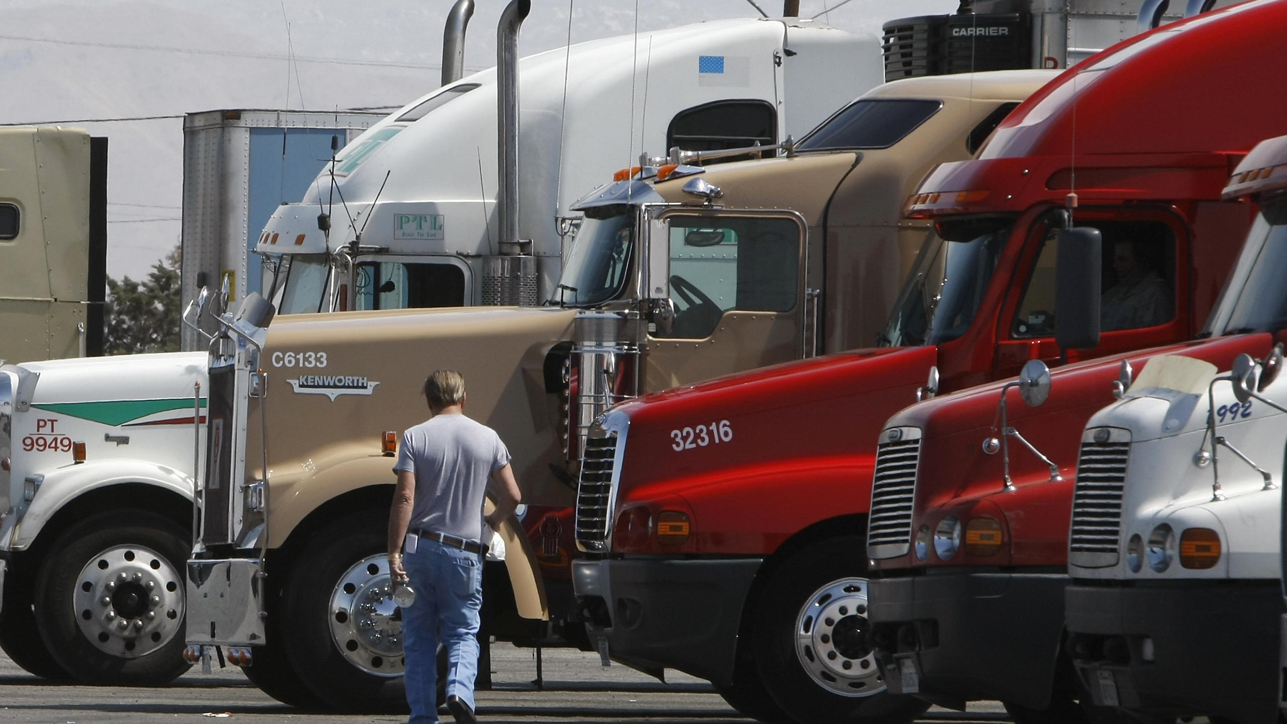 A trucker walks back to his truck at a fueling depot in Oak Hills on April 1, 2008. (Credit: Robyn Beck/AFP via Getty Images)