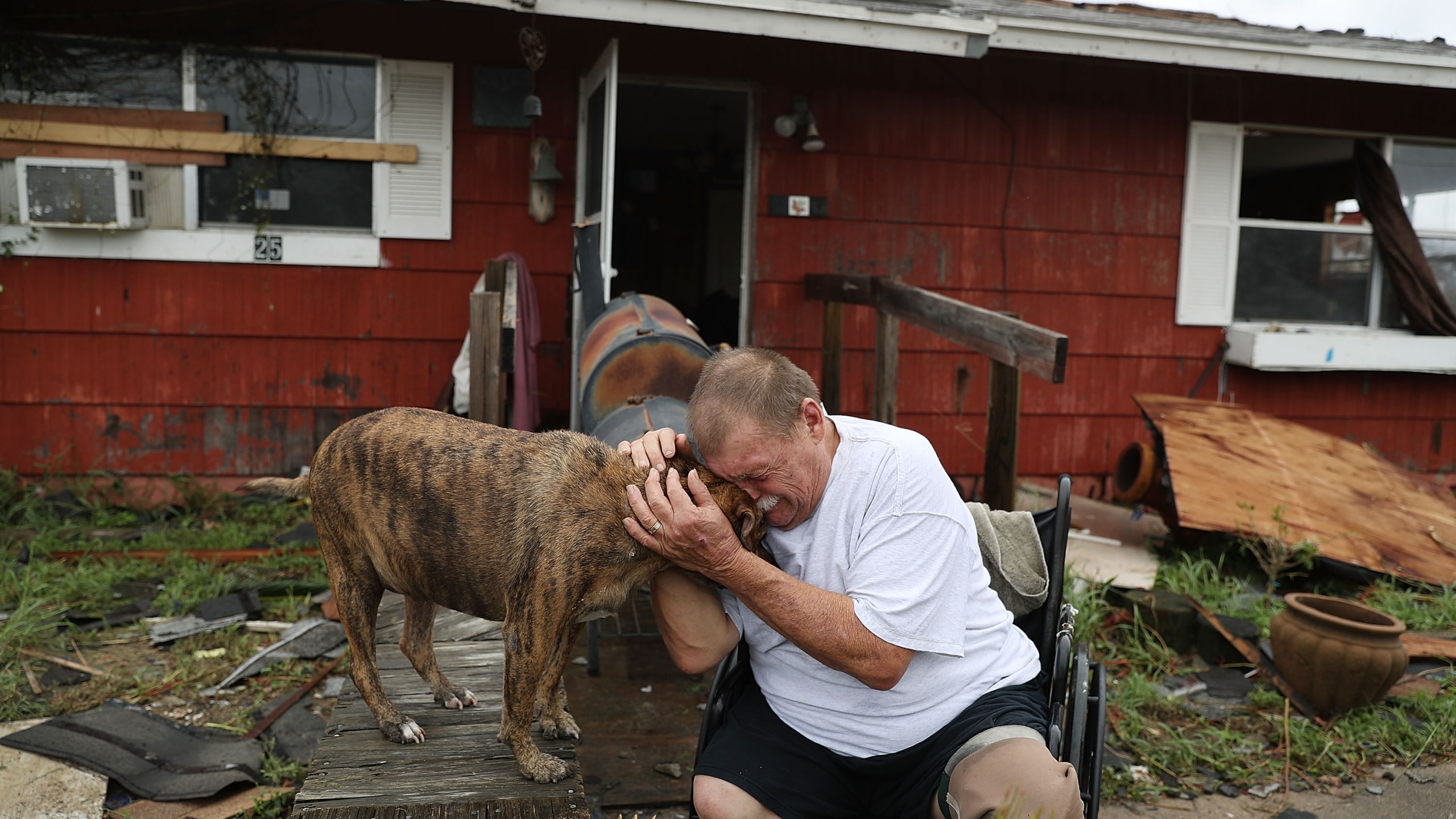 A man cries with his dog Otis after Hurricane Harvey destroyed most of his home on Aug. 26, 2017, in Rockport, Texas. (Credit: Joe Raedle/Getty Images)