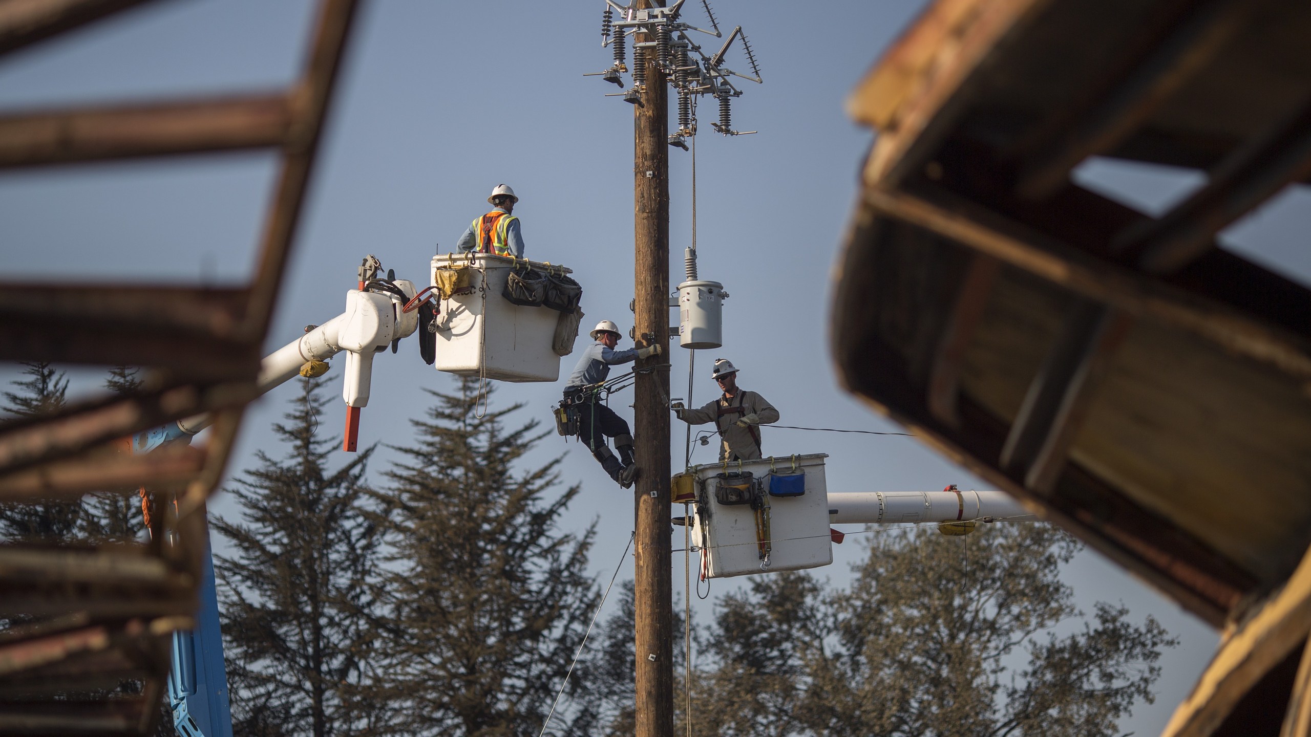 Pacific Gas & Electric Co. crews work to restore power near fire-damaged Cardinal Newman High School in Santa Rosa on Oct. 14, 2017. (Credit: David McNew / Getty Images)