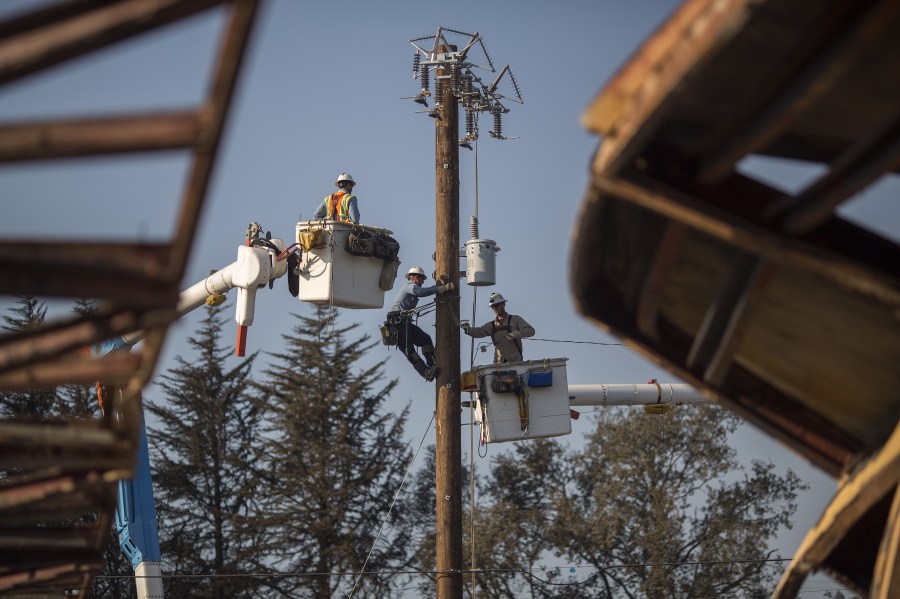 Pacific Gas & Electric Co. crews work to restore power near fire-damaged Cardinal Newman High School in Santa Rosa on Oct. 14, 2017. (Credit: David McNew / Getty Images)