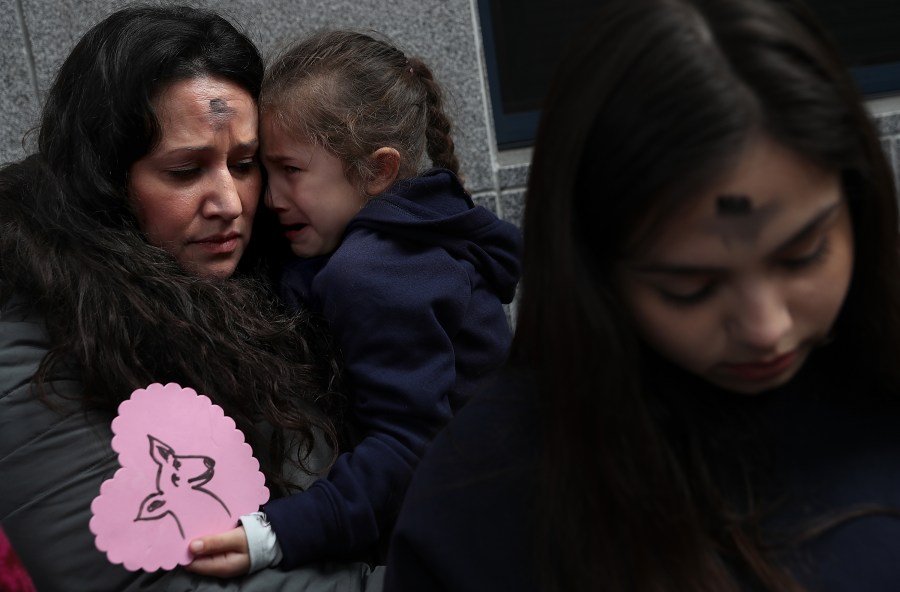 Lourdes Barraza, wife of detained immigrant Fernando Barraza, holds her crying daughter Ana Barraza during a Valentine's Day demonstration outside of the San Francisco office of the Immigration and Cutsoms Enforcement on Feb. 14, 2018 in San Francisco. (Credit: Justin Sullivan/Getty Images)