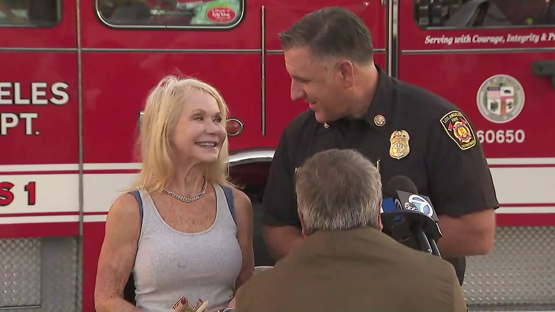 Patty Shales and Jaime Moore, assistant chief at the Los Angeles Fire Department, smile during a press briefing at a fire station in Sawtelle on Nov. 5, 2019, discussing how Shales was reunited with an heirloom that survived when the Getty Fire destroyed her Brentwood home. (Credit: KTLA)