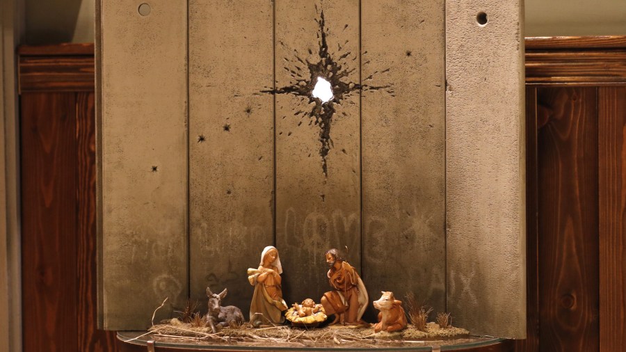 A new Christmas-themed artwork dubbed the "Scar of Bethlehem" by secretive British artist Banksy is displayed at his Walled-Off Hotel in Bethlehem in the occupied West Bank on Dec. 20, 2019. (Credit: AHMAD GHARABLI / AFP) (Photo by AHMAD GHARABLI/AFP via Getty Images)