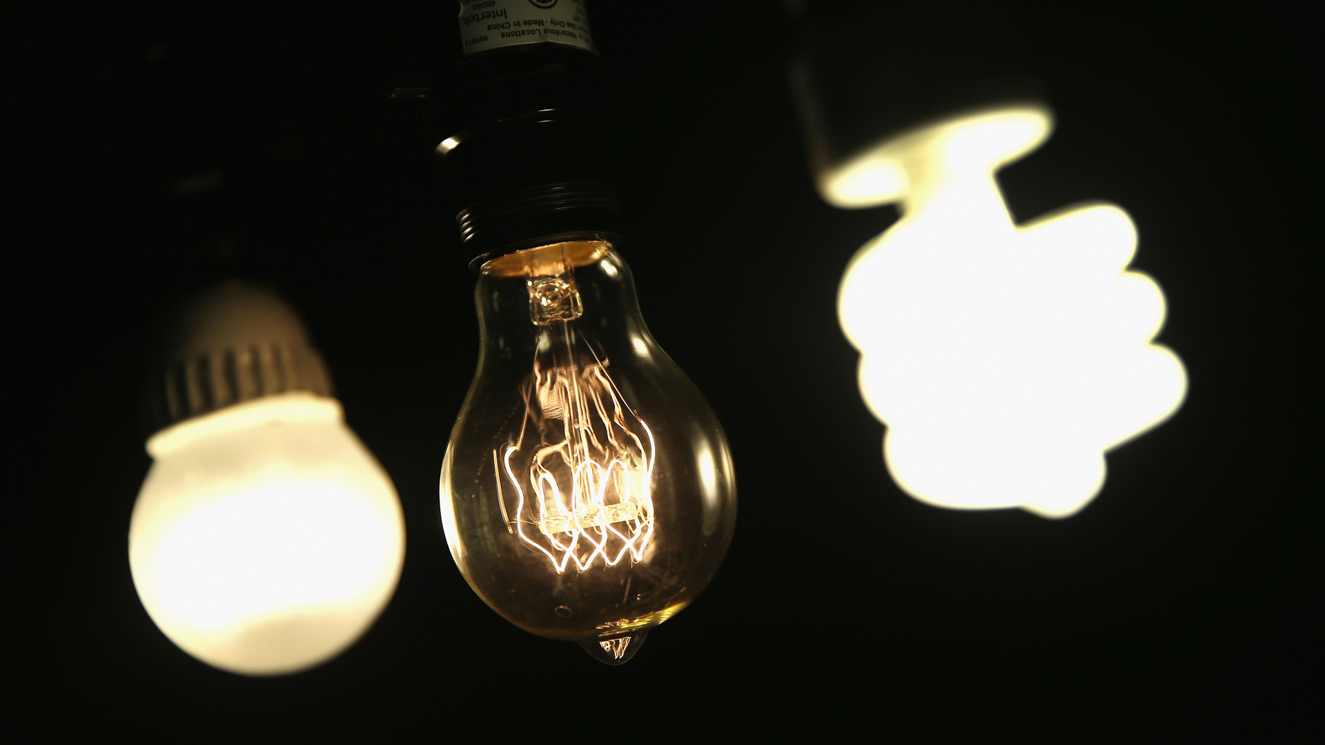 A vintage-style incandescent light bulb, center, is shown with an LED light bulb, left, and a compact florescent bulb in Chicago, Illinois, on Dec. 27, 2013. (Credit: Scott Olson / Getty Images)