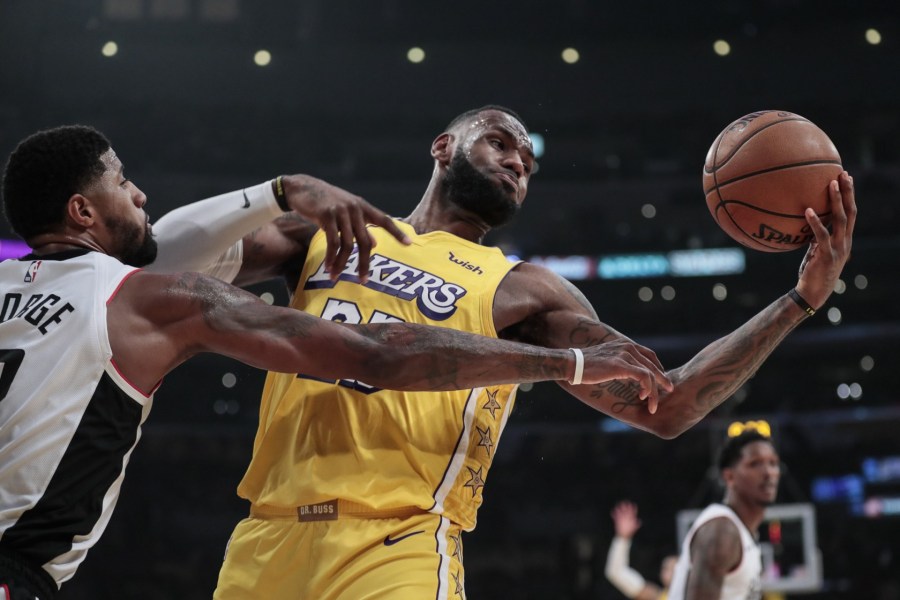 Lakers forward LeBron James tries to control a rebound against Clippers forward Paul George. (Credit: Robert Gauthier/ Los Angeles Times)