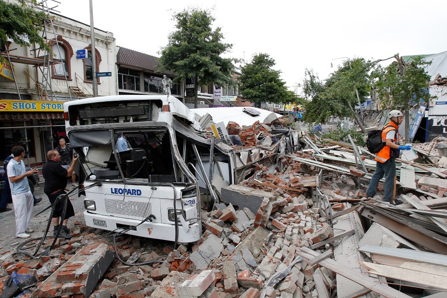 A bus covered in building debris is seen on February 22, 2011 in Christchurch, New Zealand. (Credit: Martin Hunter/Getty Images)