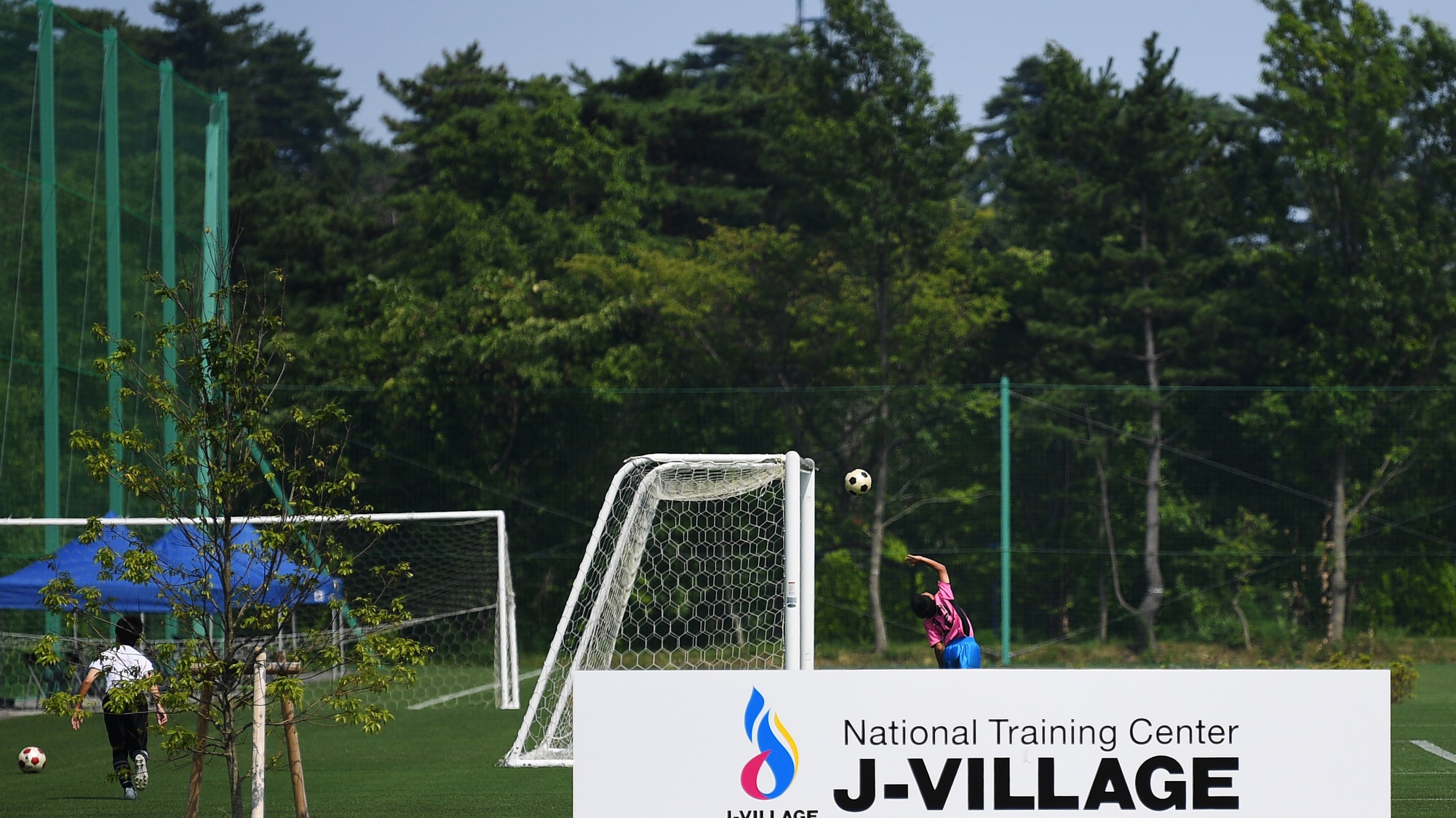 Children play football at the J-Village during a media tour in Naraha, Fukushima prefecture on August 2, 2019. (Credit: CHARLY TRIBALLEAU/AFP via Getty Images)