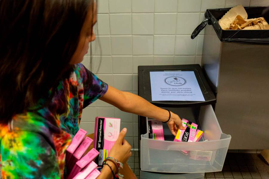 A student stocks a school bathroom with free pads and tampons to push for menstrual equity, at Justice High School in Falls Church, Virginia, on Sept. 11, 2019. (ALASTAIR PIKE/AFP via Getty Images)