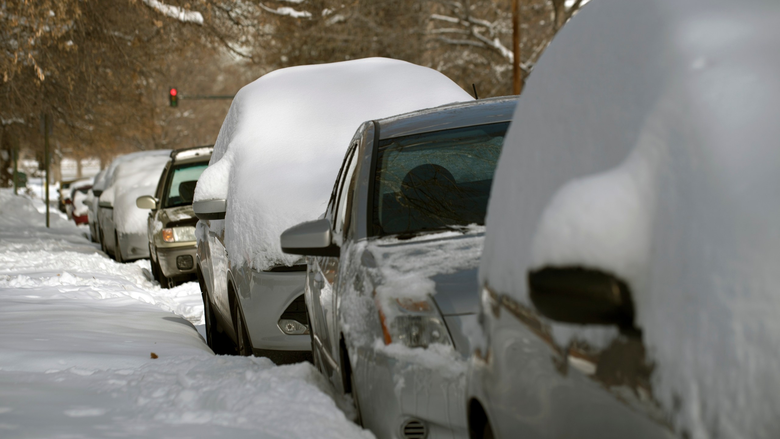 Cars lie buried under fresh snow in Denver, Colo. on Nov. 27, 2019. (Credit: JASON CONNOLLY/AFP via Getty Images)